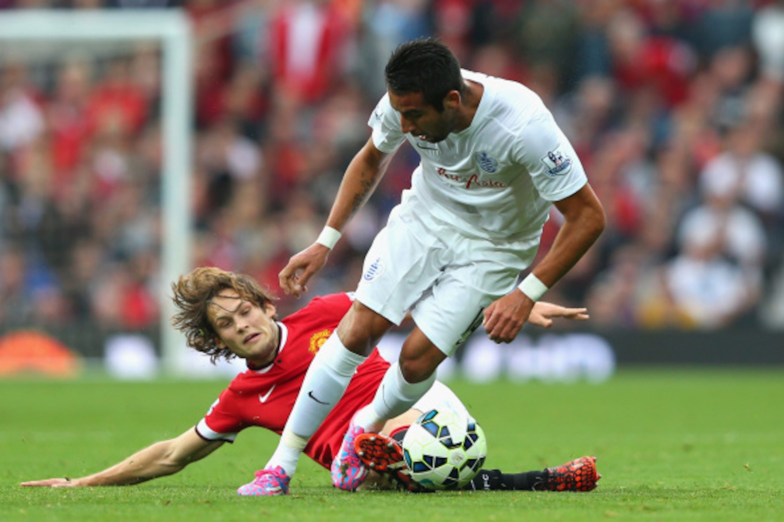 MANCHESTER, ENGLAND - SEPTEMBER 14:  Mauricio Isla of QPR is challenged by Daley Blind of Manchester United during the Barclays Premier League match between Manchester United and Queens Park Rangers at Old Trafford on September 14, 2014 in Manchester, Eng