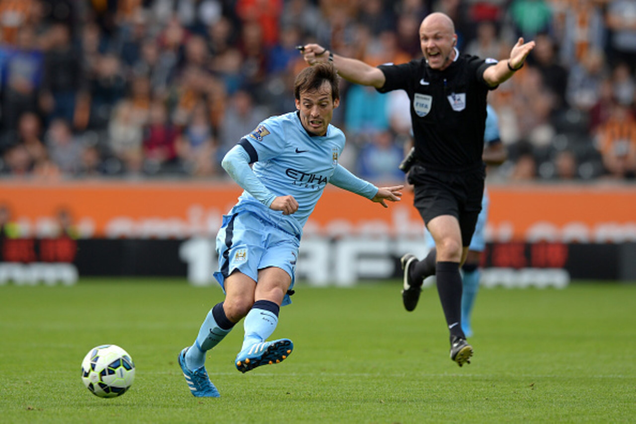 HULL, ENGLAND - SEPTEMBER 27: David Silva of Manchester City passes the ball as referee Anthony Taylor waves play on during the Barclays Premier League match between Hull City and Manchester City at KC Stadium on September 27, 2014 in Hull, England. (Ph HULL, ENGLAND - SEPTEMBER 27: David Silva of Manchester City passes the ball as referee Anthony Taylor waves play on during the Barclays Premier League match between Hull City and Manchester City at KC Stadium on September 27, 2014 in Hull, England. (Ph