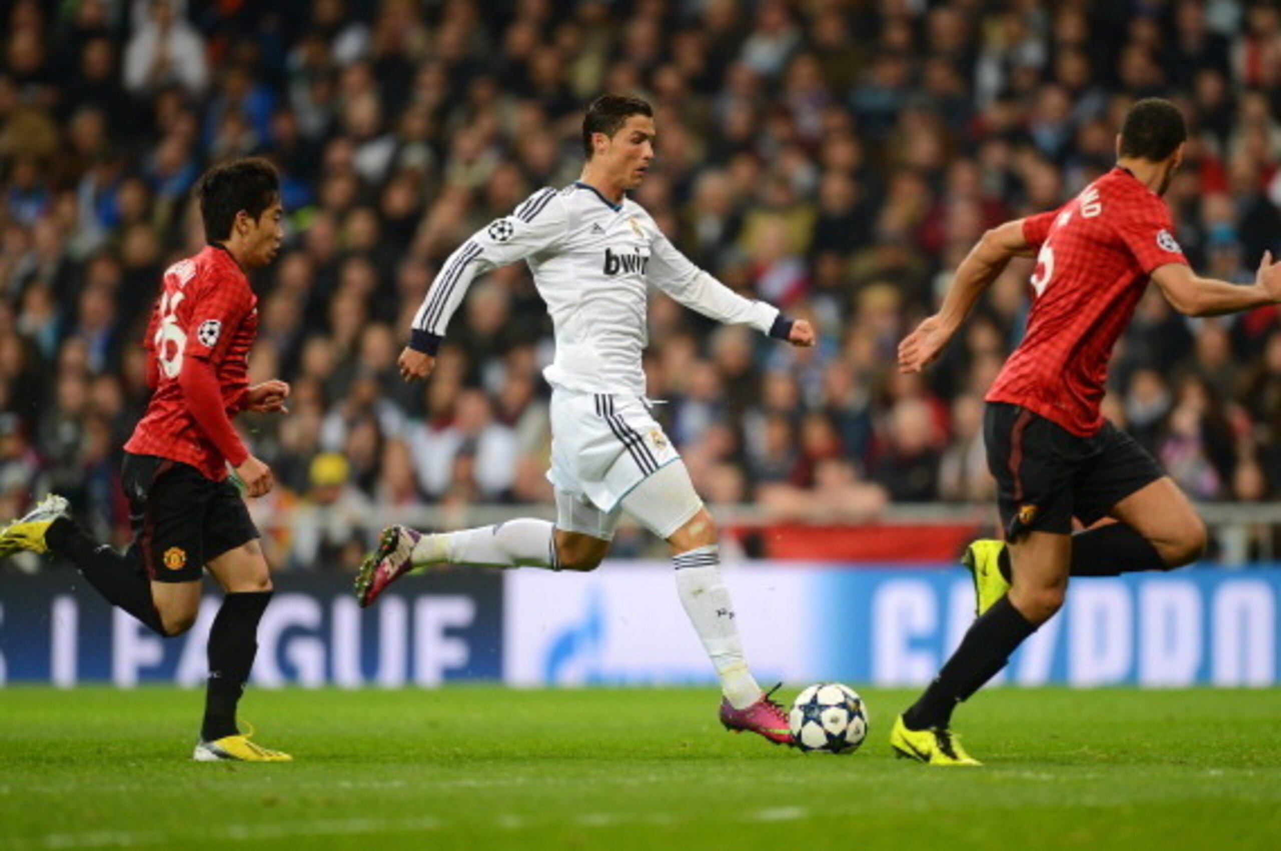 MADRID, SPAIN - FEBRUARY 13:  Cristiano Ronaldo of Real Madrid is marshalled by Shinji Kagawa of Manchester United and Rio Ferdinand of Manchester United during the UEFA Champions League Round of 16 first leg match between Real Madrid and Manchester Unite