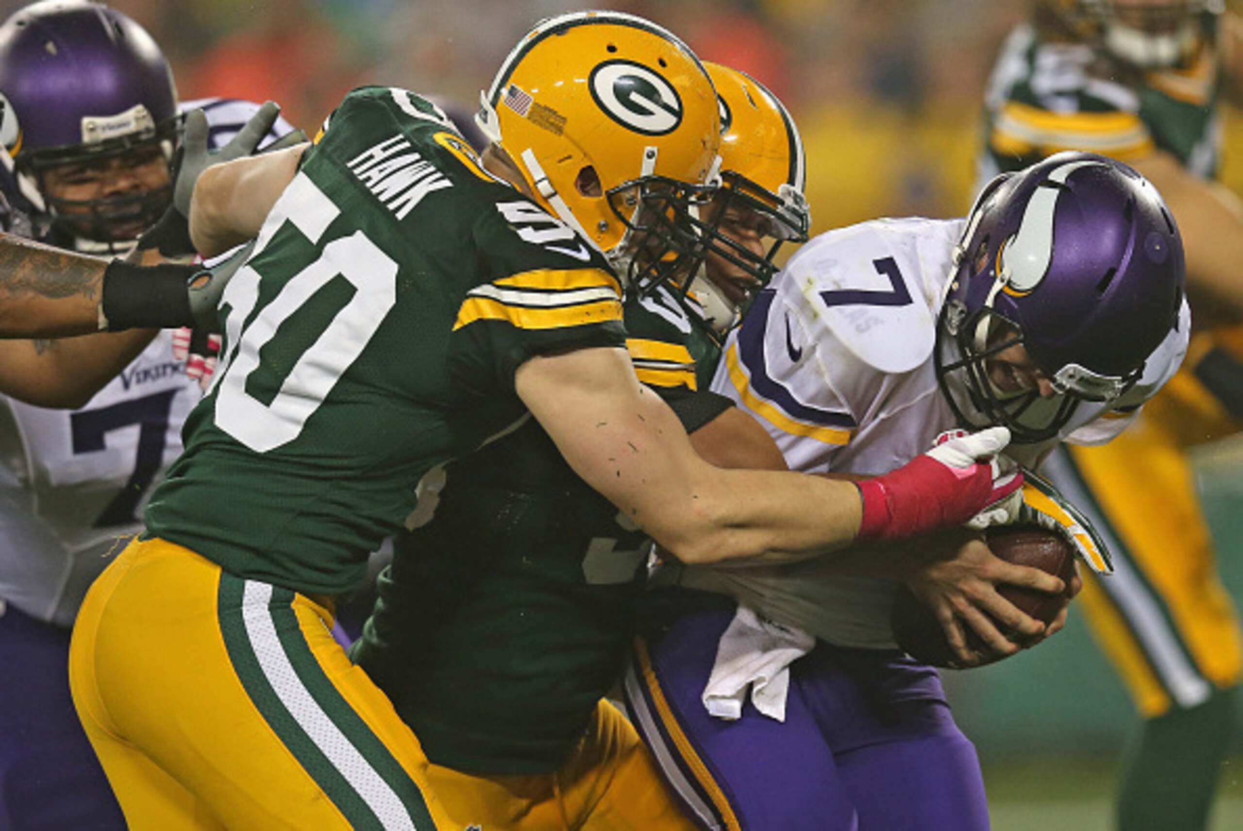 GREEN BAY, WI - OCTOBER 02:  Quarterback  Christian Ponder #7 of the Minnesota Vikings is sacked by  Nick Perry #53 and  A.J. Hawk #50 of the Green Bay Packers in the second quarter of the NFL game at Lambeau Field on October 2, 2014 in Green Bay, Wiscons