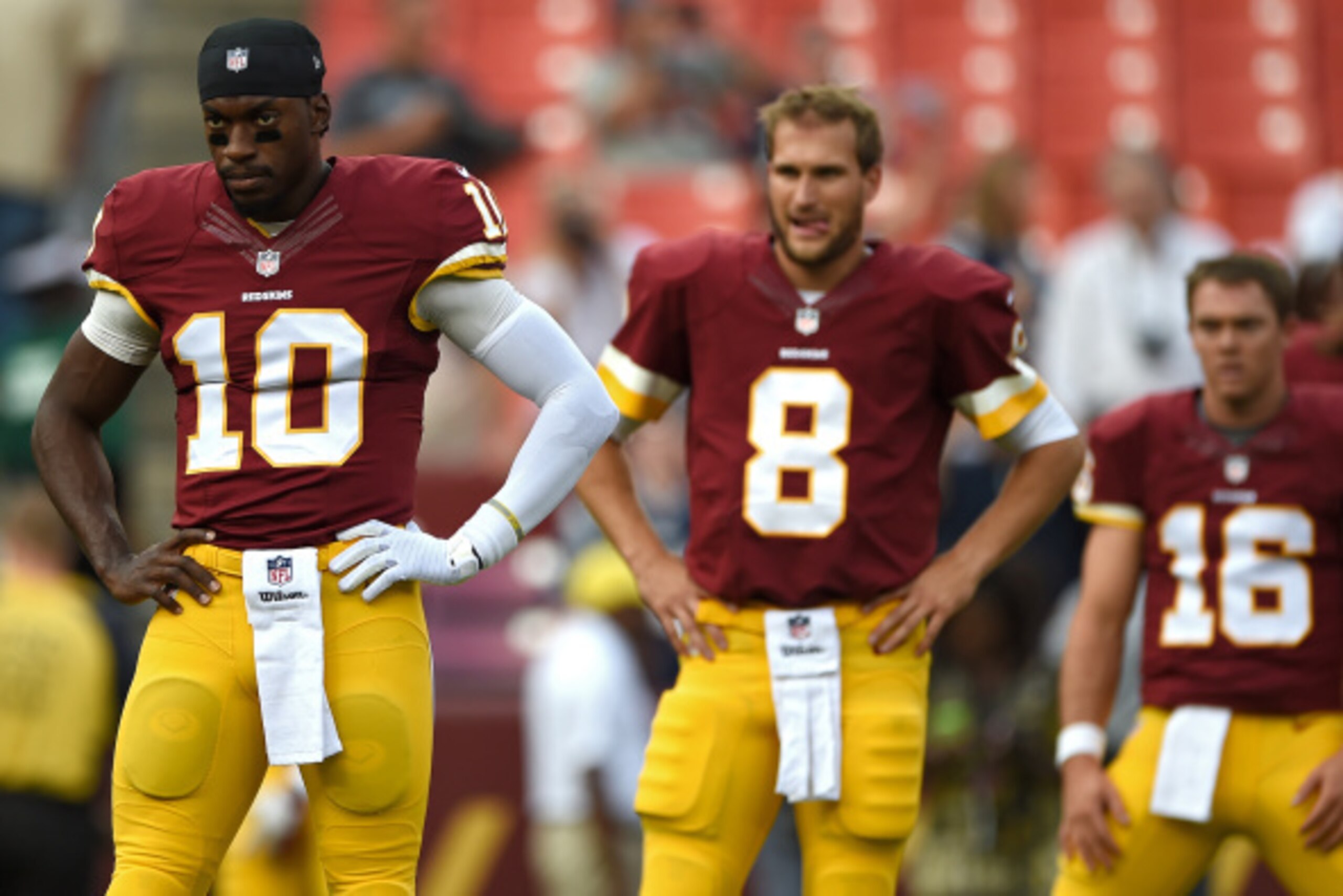 LANDOVER, MD - AUGUST 07: Quarterback Robert Griffin III #10, quarterback Kirk Cousins #8, and quarterback Colt McCoy #16 of the Washington Redskins look on before playing the New England Patriots during their preseason NFL game at FedExField on August 7,