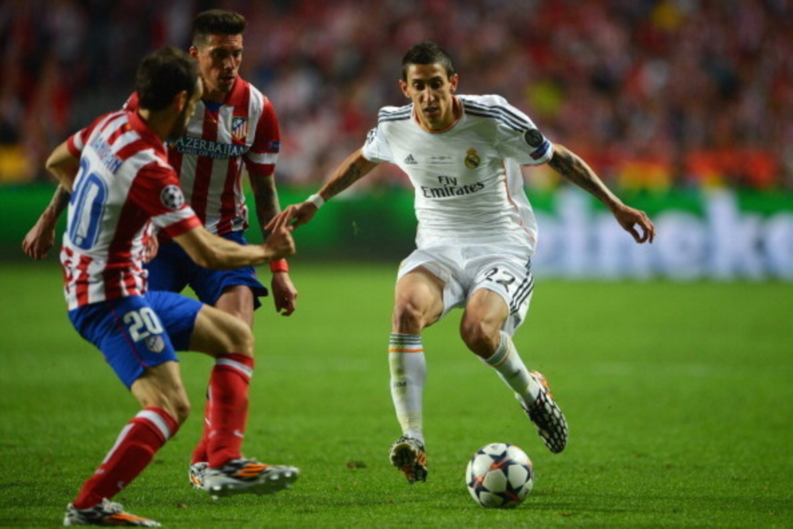 LISBON, PORTUGAL - MAY 24:  Angel Di Maria of Real Madrid takes on Juanfran (L) and Jose Sosa of Club Atletico de Madrid (C) during the UEFA Champions League Final between Real Madrid and Atletico de Madrid at Estadio da Luz on May 24, 2014 in Lisbon, Por