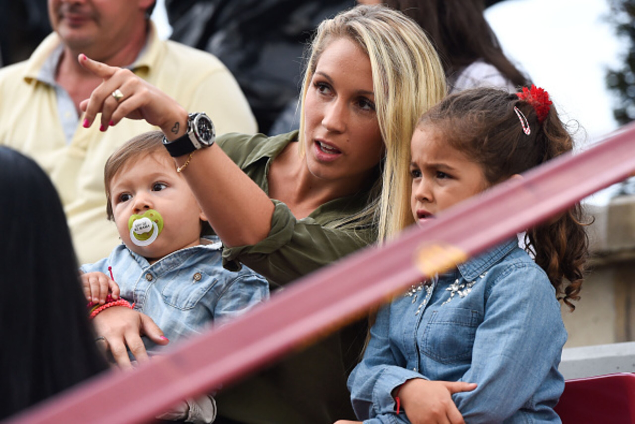 BARCELONA, SPAIN - SEPTEMBER 24:  Luis Suarez's wife Sofia Balbi holds her son Benjamin Suarez as she talks with her daughter Delfina Suarez during a friendly match between FC Barcelona B and Indonesia U19 at Ciutat Esportiva on September 24, 2014 in Barc
