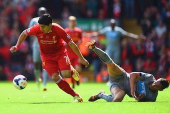 LIVERPOOL, ENGLAND - MAY 11:  Luis Suarez of Liverpool evades Mathieu Debuchy of Newcastle United during the Barclays Premier League match between Liverpool and Newcastle United at Anfield on May 11, 2014 in Liverpool, England.  (Photo by Laurence Griffit