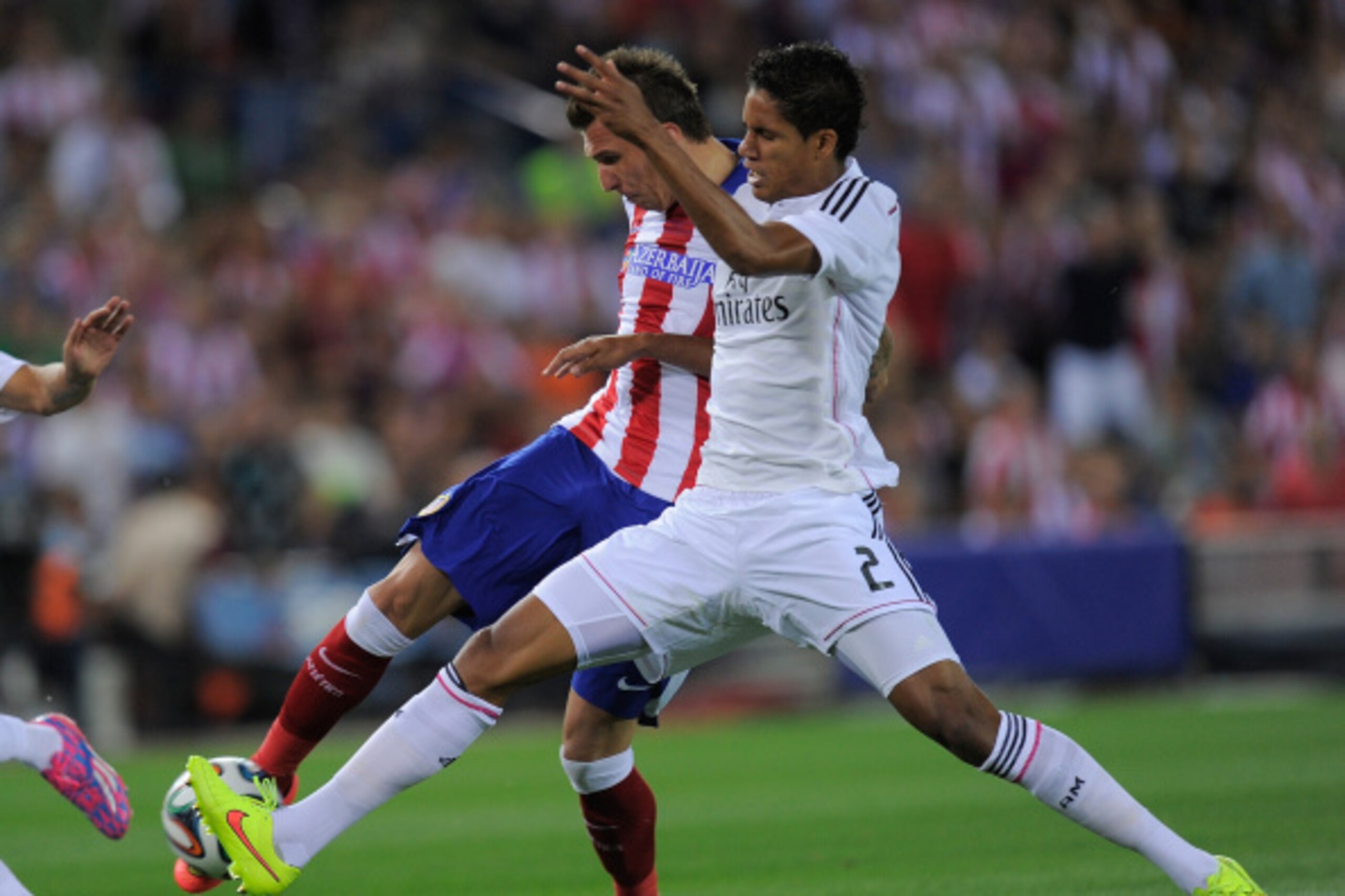 MADRID, SPAIN - AUGUST 22:  Mario Mandzukic of Club Atletico de Madrid beats Raphael Varane of Real Madrid to score his team's opening goal during the Supercopa, second leg match between Club Atletico de Madrid and Real Madrid at Vicente Caldron stadium o