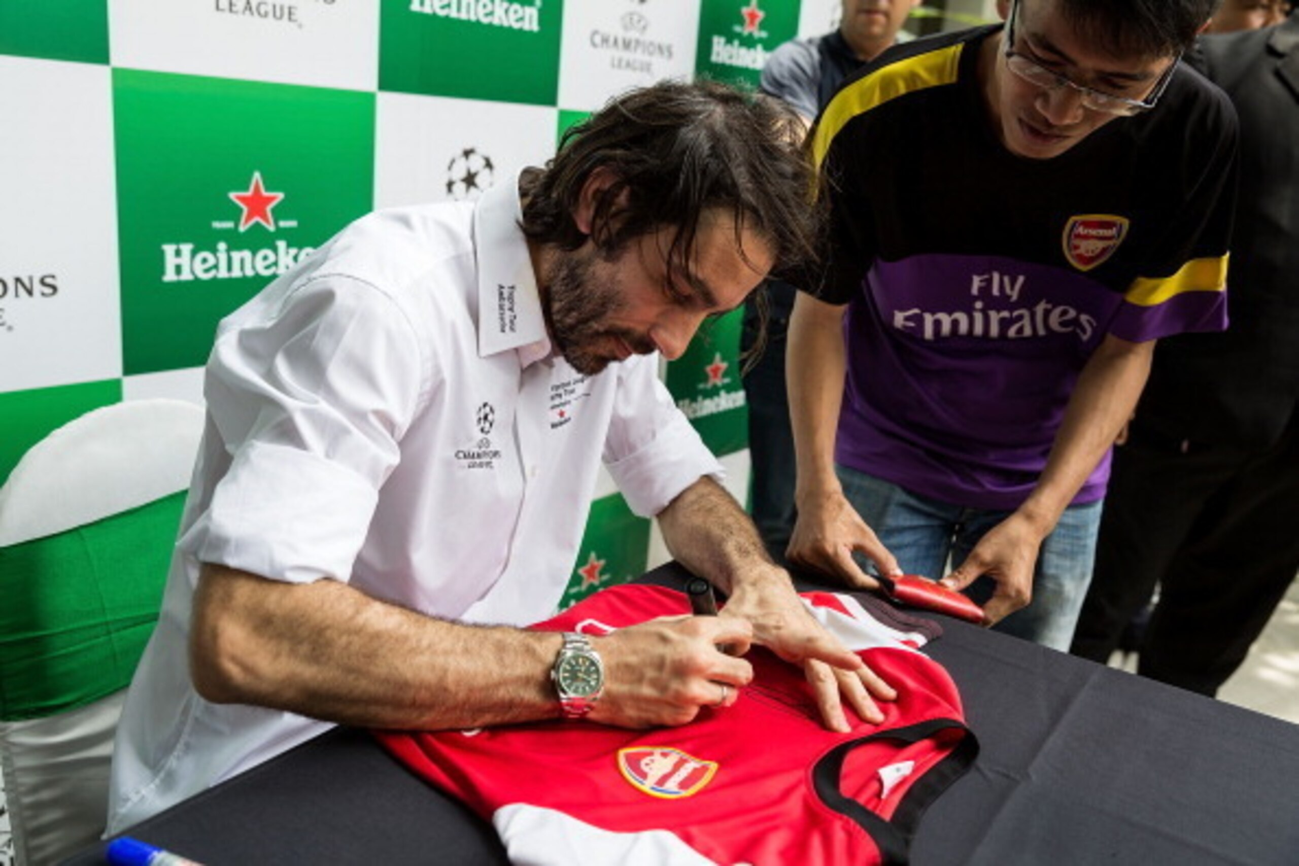 HO CHI MINH CITY, VIETNAM - APRIL 05:  Robert Pires signs memorabilia during the Heineken UEFA Champions League Trophy tour on April 5, 2014 in Ho Chi Minh City, Vietnam. Football fans were given the opportunity to visit with the Heineken UEFA Champions L