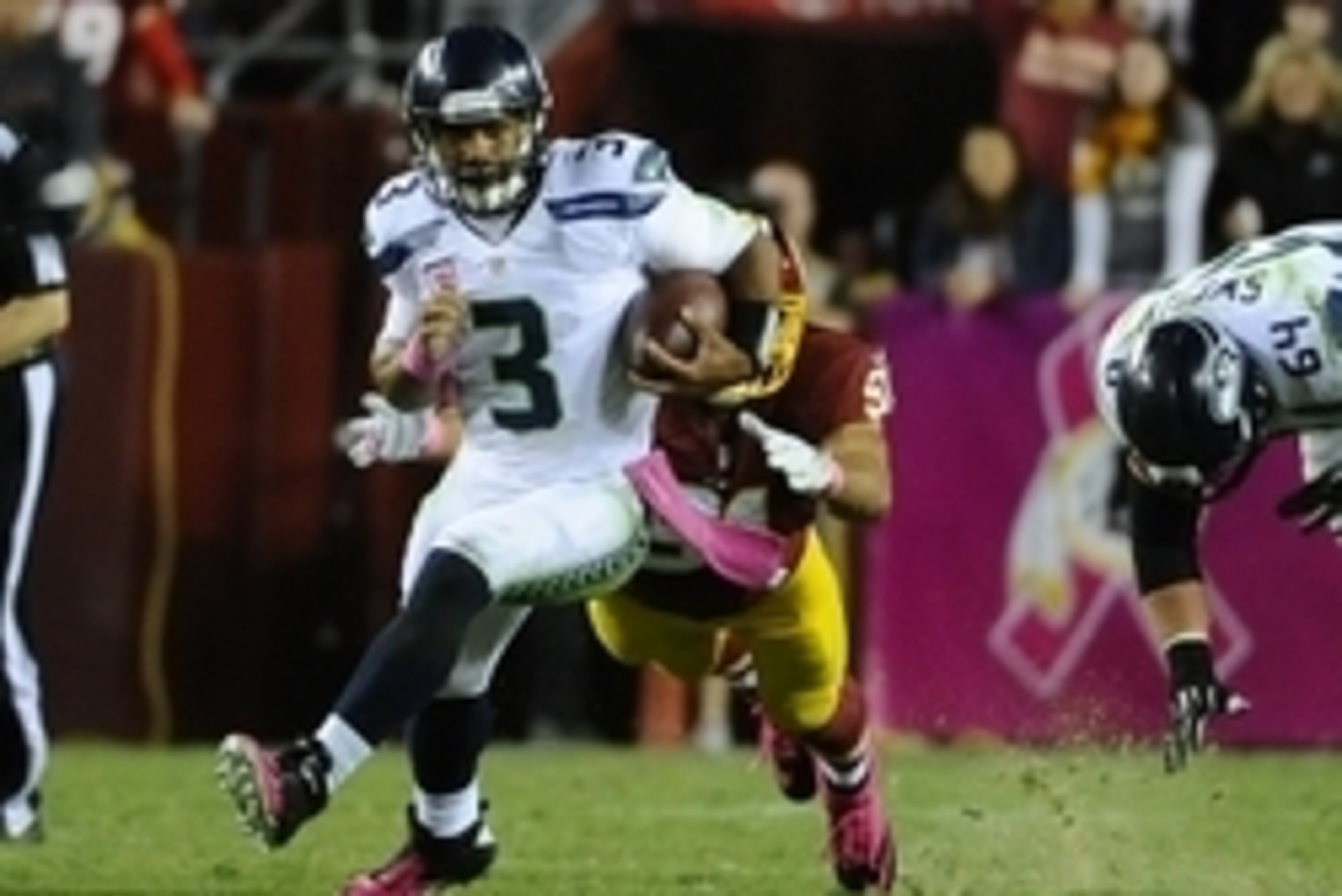 Oct 6, 2014; Landover, MD, USA; Seattle Seahawks quarterback Russell Wilson (3) runs with the ball as Washington Redskins outside linebacker Ryan Kerrigan (91) chases during the second half at FedEx Field. The Seahawks won 27-17. Mandatory Credit: Brad Mi