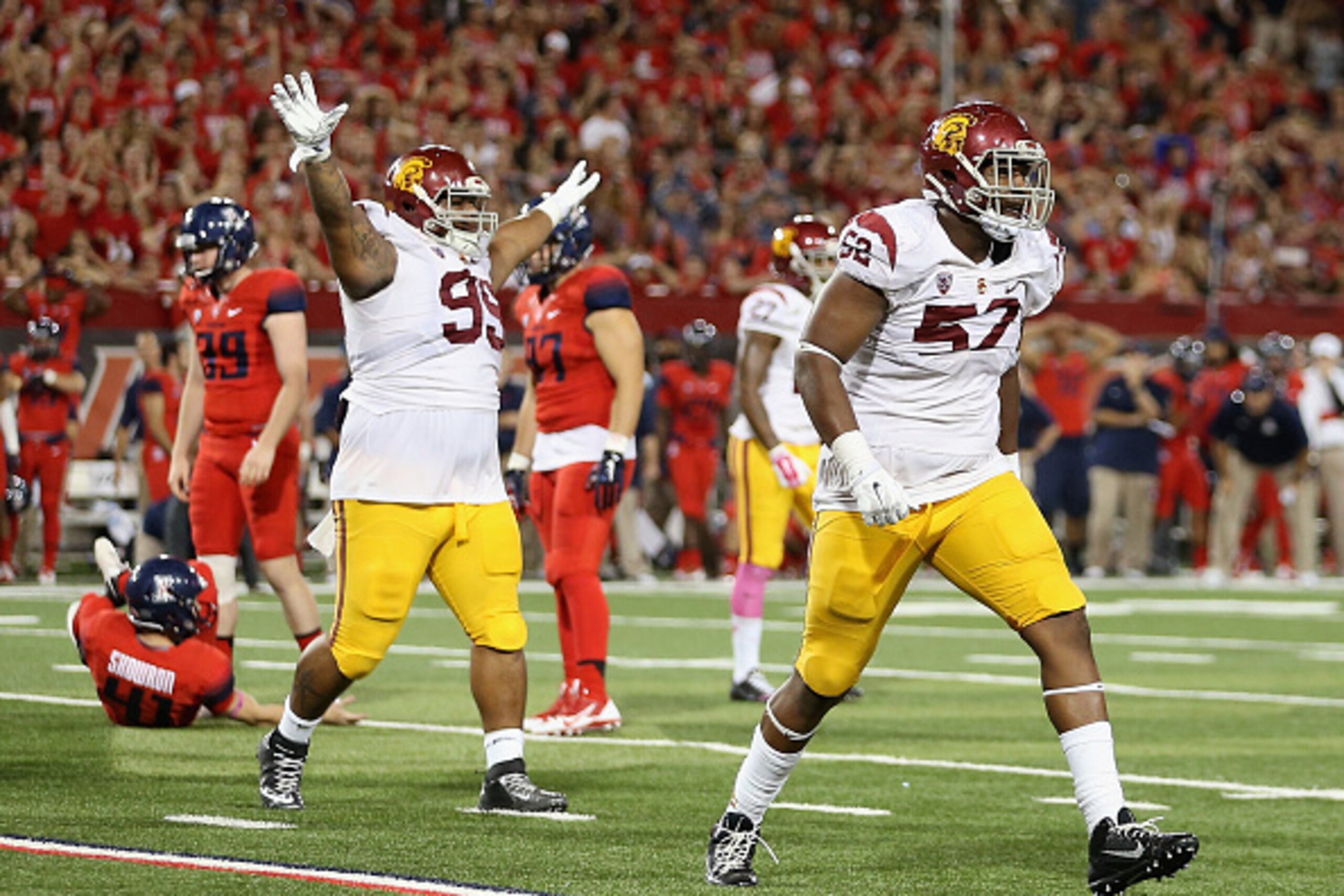 TUCSON, AZ - OCTOBER 11:  Defensive tackle Antwaun Woods #99 and linebacker Nick Schlossberg #57 of the USC Trojans react after place kicker Casey Skowron #41 (L) of the Arizona Wildcats missed a field goal during the final moments of the college football