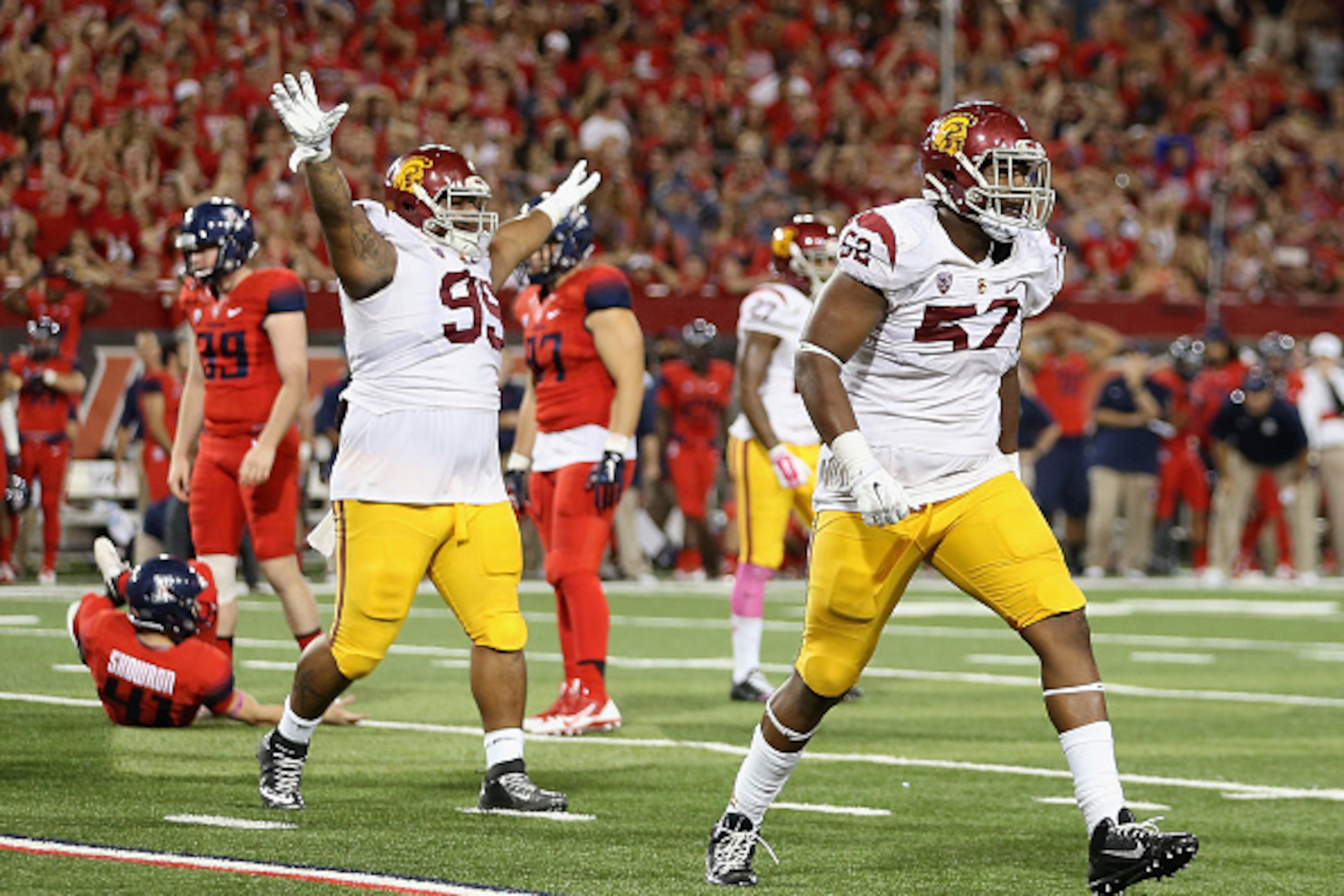 TUCSON, AZ - OCTOBER 11:  Defensive tackle Antwaun Woods #99 and linebacker Nick Schlossberg #57 of the USC Trojans react after place kicker Casey Skowron #41 (L) of the Arizona Wildcats missed a field goal during the final moments of the college football