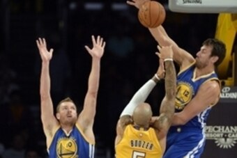 Oct 9, 2014; Los Angeles, CA, USA; Golden State Warriors center Andrew Bogut (12) blocks the shot of Los Angeles Lakers forward Carlos Boozer (5) during the first half at Staples Center. Mandatory Credit: Richard Mackson-USA TODAY Sports