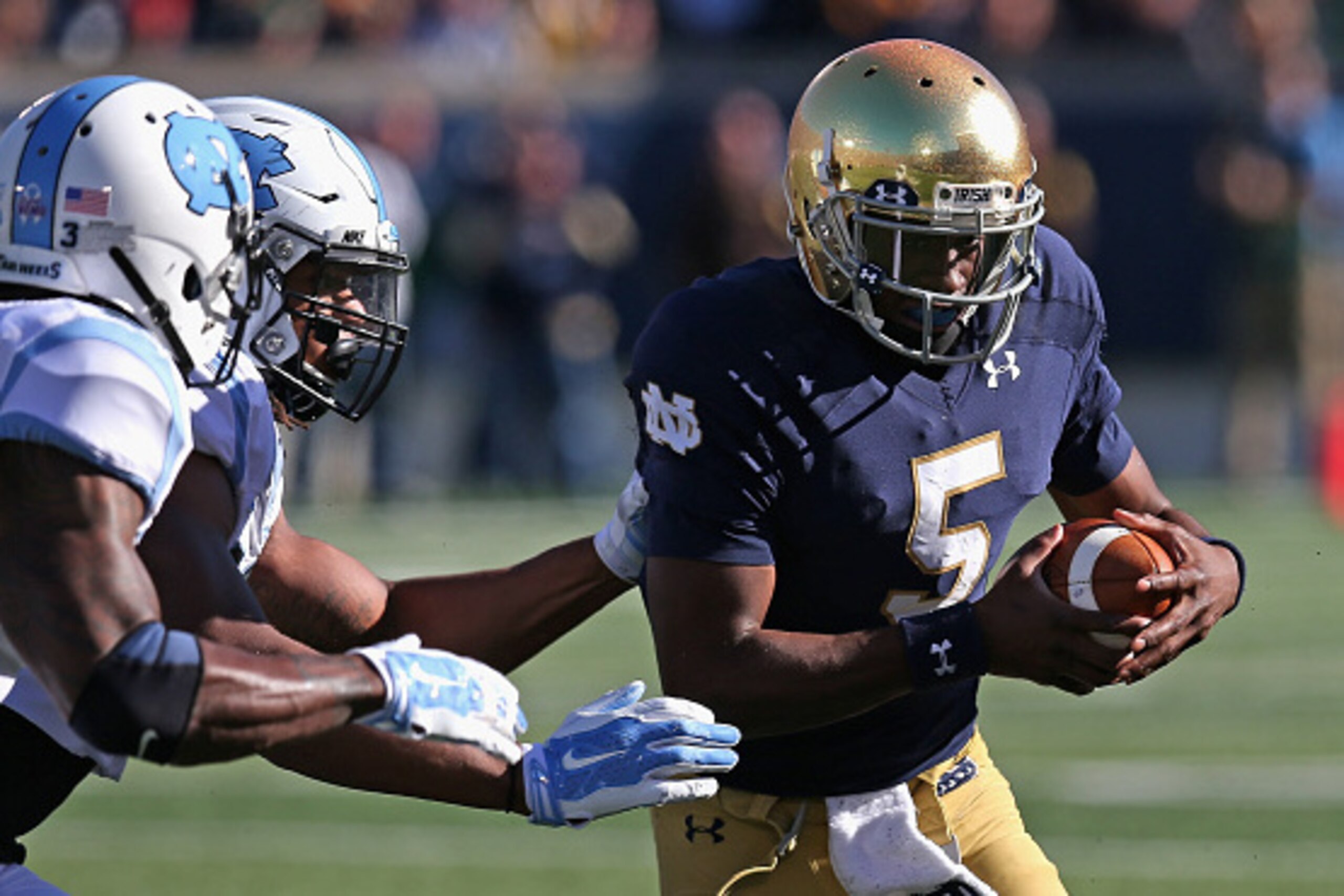 SOUTH BEND, IN - OCTOBER 11: Everett Golson #5 of the Notre Dame Fighting Irishtires to break away from Sam Smiley #3 (L) and Dajaun Drennon #17 of the North Carolina Tar Heels at Notre Dame Stadium on October 11, 2014 in South Bend, Indiana. (Photo by SOUTH BEND, IN - OCTOBER 11: Everett Golson #5 of the Notre Dame Fighting Irishtires to break away from Sam Smiley #3 (L) and Dajaun Drennon #17 of the North Carolina Tar Heels at Notre Dame Stadium on October 11, 2014 in South Bend, Indiana. (Photo by