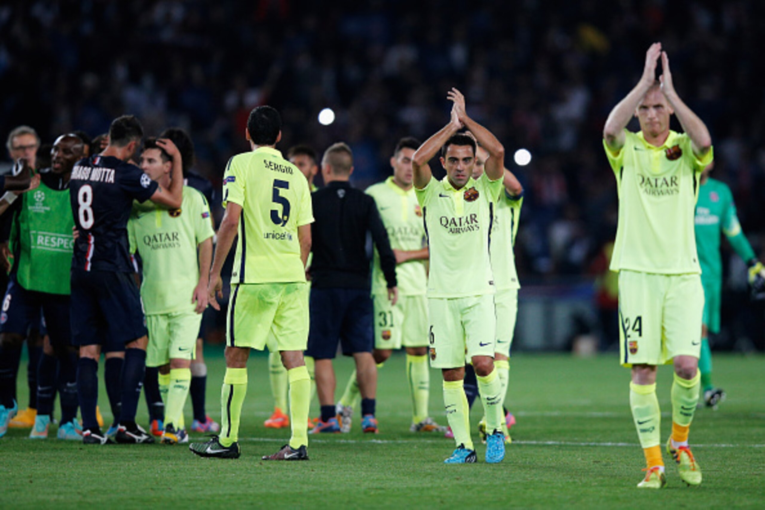 PARIS, FRANCE - SEPTEMBER 30:  Xavi #6 and Jeremy Mathieu#24 of Barcelona applaude the away fans after defeat in the Group F UEFA Champions League match between Paris Saint-Germain v FC Barcelona held at Parc des Princes on September 30, 2014 in Paris, Fr