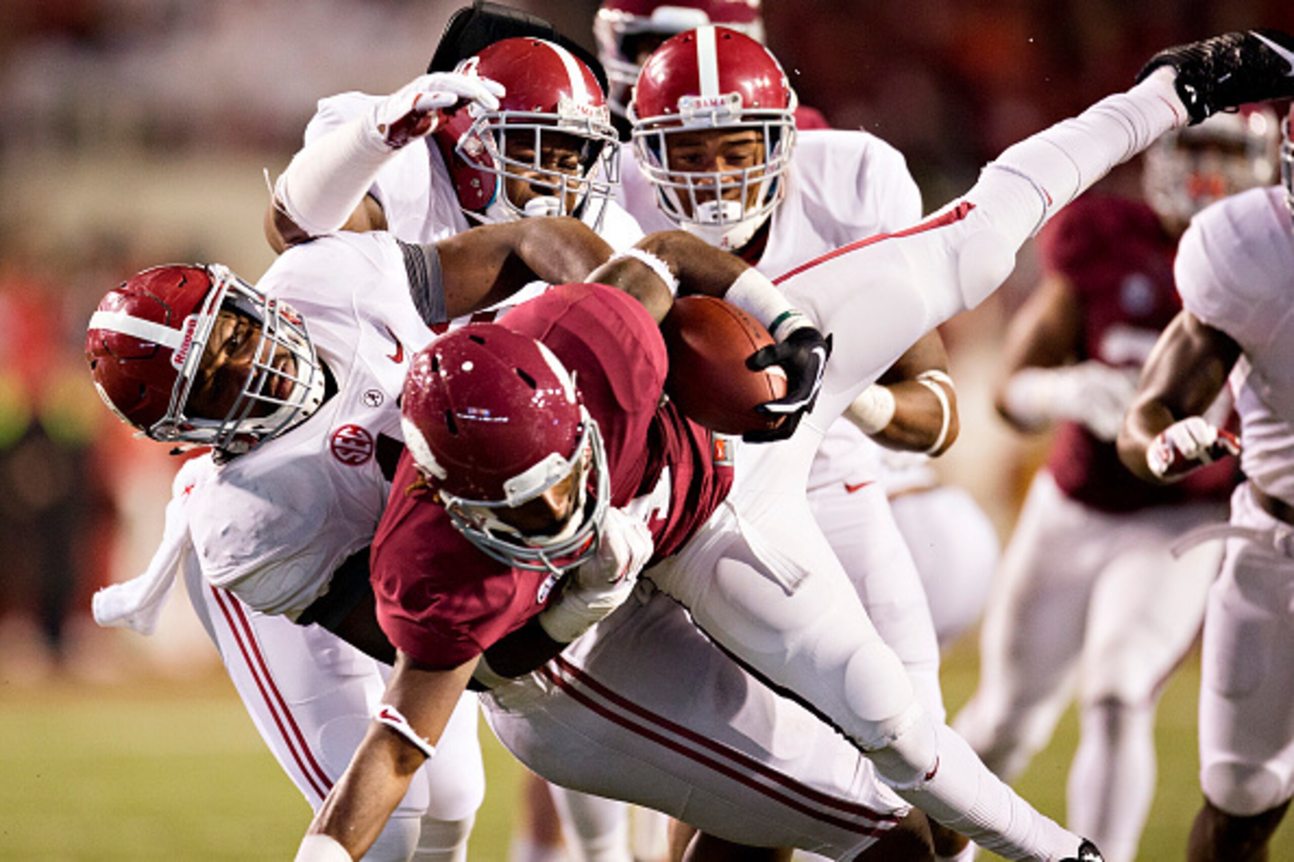 FAYETTEVILLE, AR - OCTOBER 11:  Eric Hawkins #14 of the Arkansas Razorbacks is tackled by Reggie Ragland #19 of the Alabama Crimson Tide at Razorback Stadium on October 11, 2014 in Fayetteville, Arkansas.  The Crimson Tide defeated the Razorbacks 14-13.  