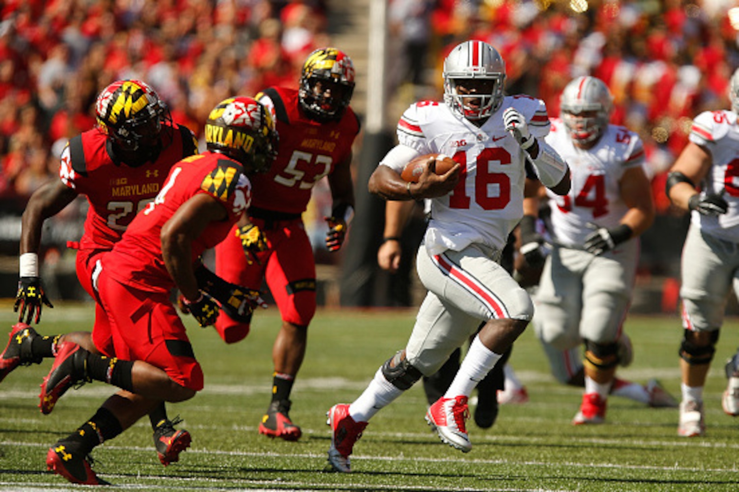 COLLEGE PARK, MD - OCTOBER 04:  Quarterback J.T. Barrett #16 of the Ohio State Buckeyes runs with the ball against the Maryland Terrapin defense during the first half of Ohio State's 52-24 win at Byrd Stadium on October 4, 2014 in College Park, Maryland. 