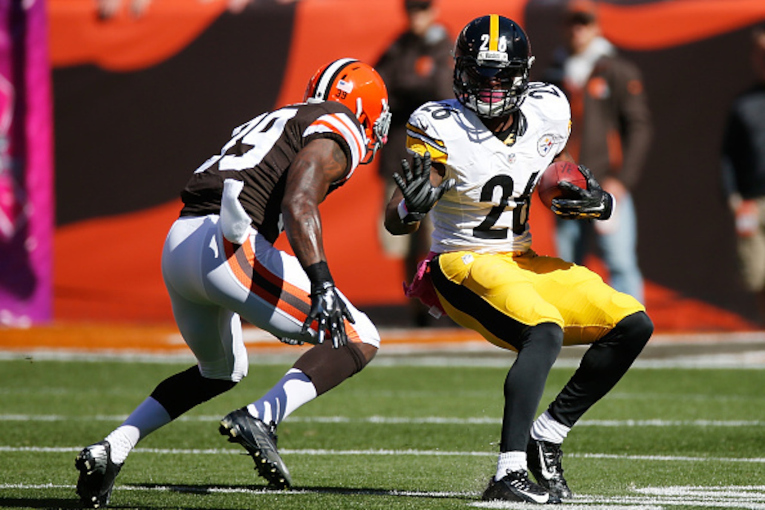 CLEVELAND, OH - OCTOBER 12:  Le'Veon Bell #26 of the Pittsburgh Steelers carries the ball in front of Tashaun Gipson #39 of the Cleveland Browns during the first quarter at FirstEnergy Stadium on October 12, 2014 in Cleveland, Ohio.  (Photo by Gregory Sha