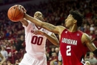 Nov 15, 2013; Fayetteville, Ar, USA; Louisiana-Lafayette Ragin' Cajuns guard Elfrid Payton (2) and Arkansas Razorback guard Rashad Madden (00) battle for control of a rebound during the second half at Bud Walton Arena Arena. Arkansas defeated Louisiana-La