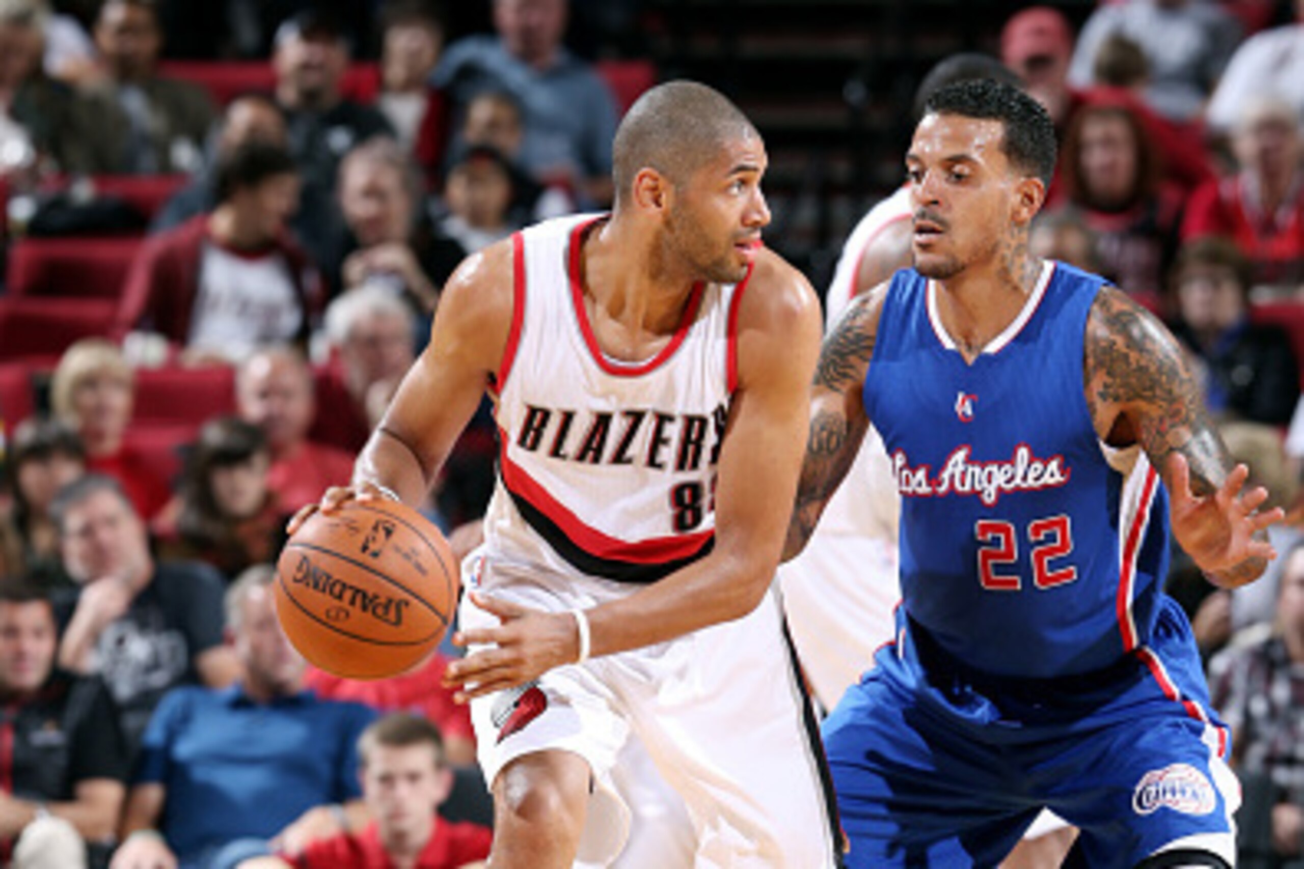 PORTLAND, OR - OCTOBER 12: Nicolas Batum #88 of the Portland Trail Blazers handles the ball against Matt Barnes #22 of the Los Angeles Clippers on October 12, 2014 at the Moda Center Arena in Portland, Oregon. NOTE TO USER: User expressly acknowledges and