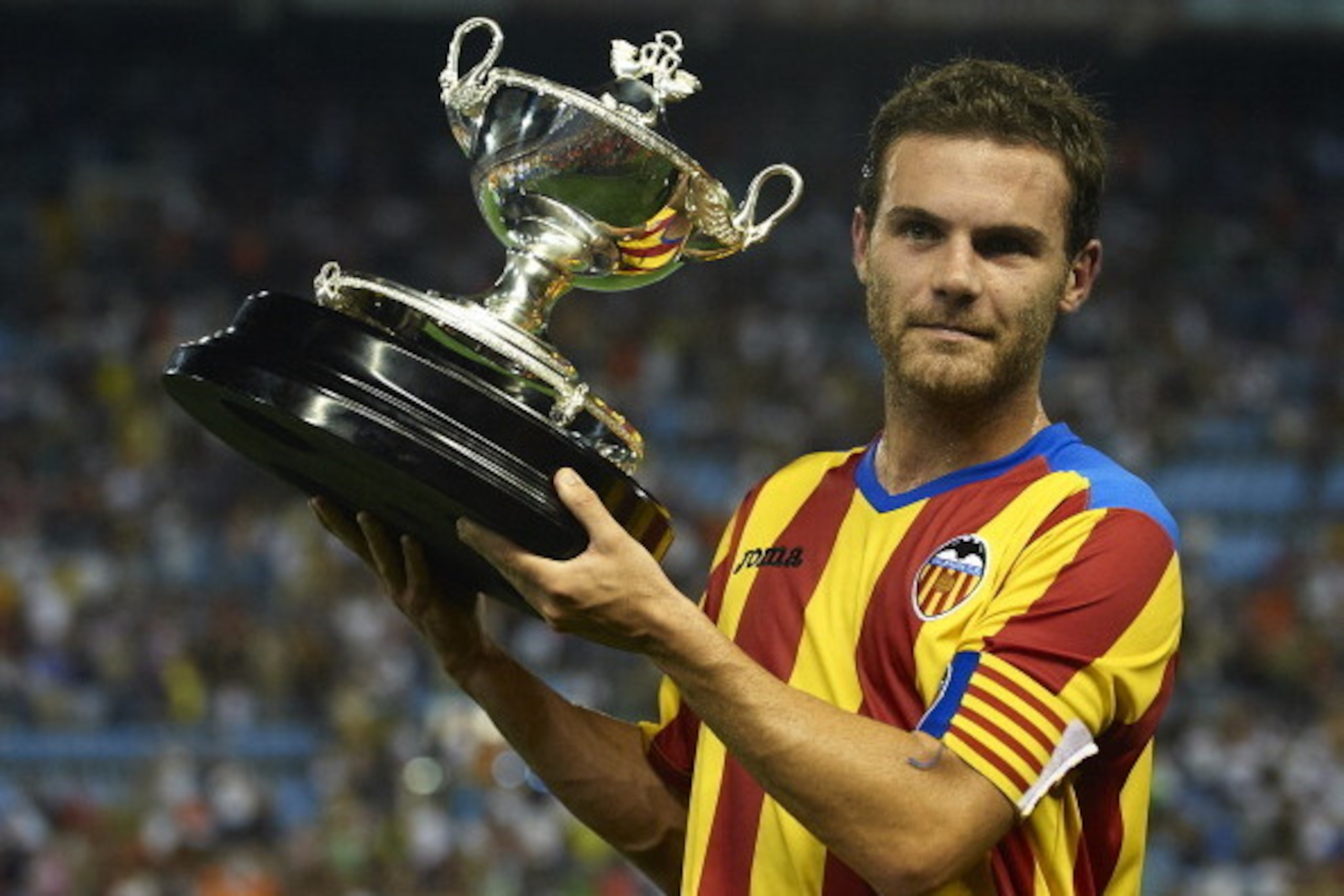 VALENCIA, SPAIN - AUGUST 12:  Juan Mata of Valencia lifts the winners trophy after the Orange Trophy match between Valencia and Roma at Estadio Mestalla on August 12, 2011 in Valencia, Spain.  (Photo by Manuel Queimadelos Alonso/Getty Images)
