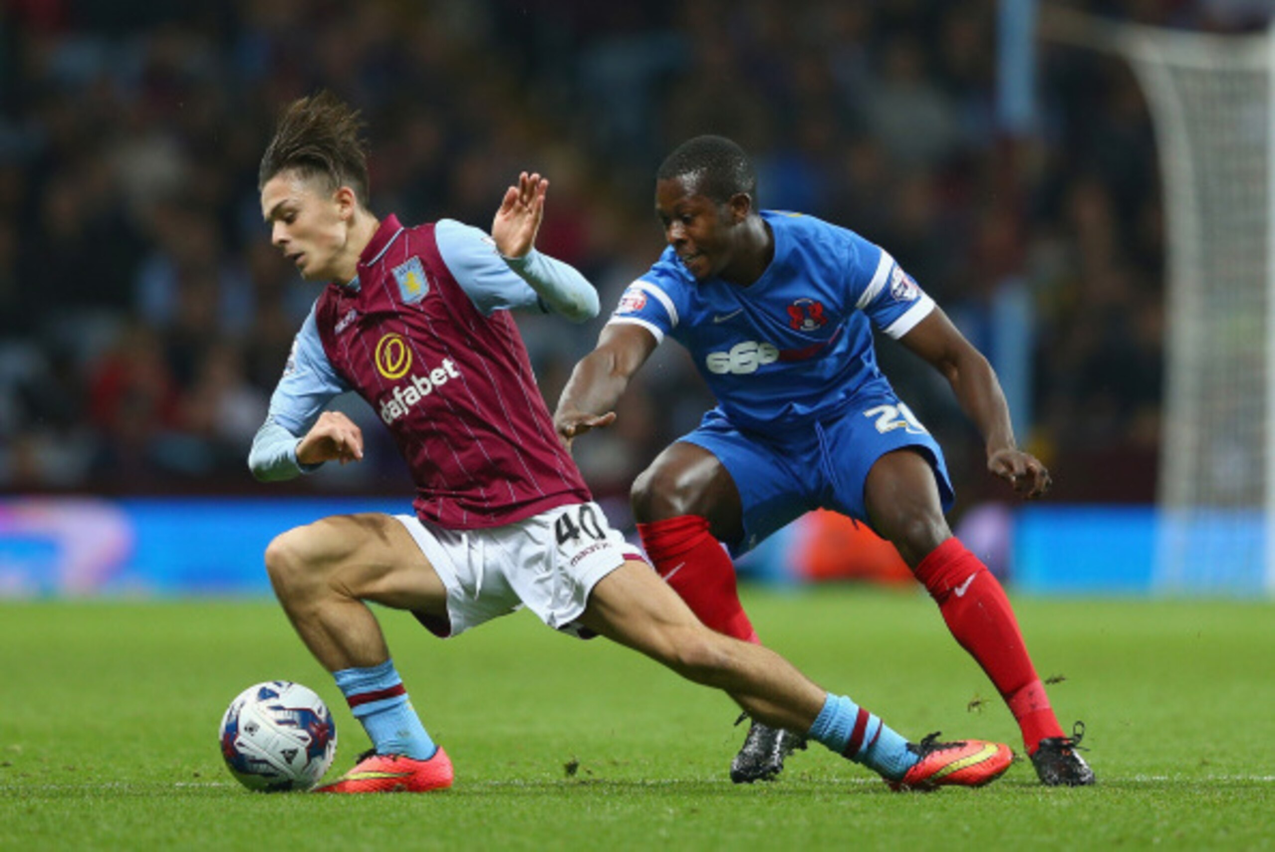 BIRMINGHAM, ENGLAND - AUGUST 27:  Jack Grealish of Aston Villa holds off a challenge from Marvin Bartley of Leyton Orient during the Capital One Cup second round match between Aston Villa and Leyton Orient at Villa Park on August 27, 2014 in Birmingham, E