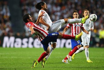 LISBON, PORTUGAL - MAY 24:  Raul Garcia of Club Atletico de Madrid and Sami Khedira of Real Madrid battle for the ball during the UEFA Champions League Final between Real Madrid and Atletico de Madrid at Estadio da Luz on May 24, 2014 in Lisbon, Portugal.