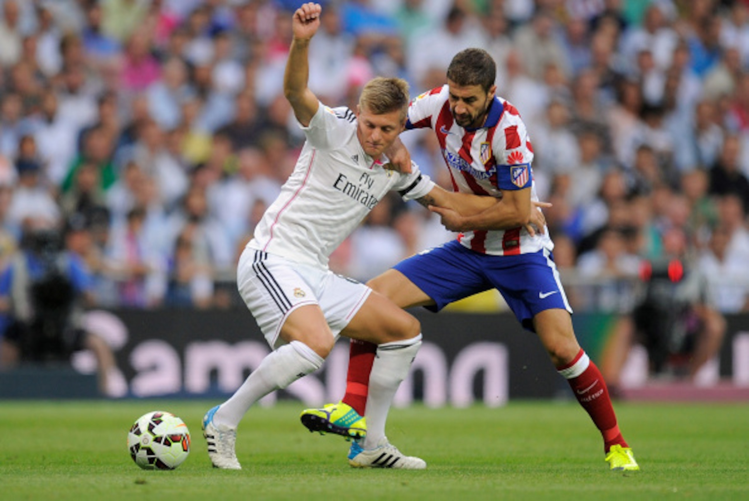 MADRID, SPAIN - SEPTEMBER 13:  Toni Kroos (L) of Real Madrid is fouled  by Gabi Fernandez of Atletico de Madrid during the La Liga match between Real Madrid and Atletico de Madrid at Estadio Santiago Bernabeu on September 13, 2014 in Madrid, Spain.  (Phot