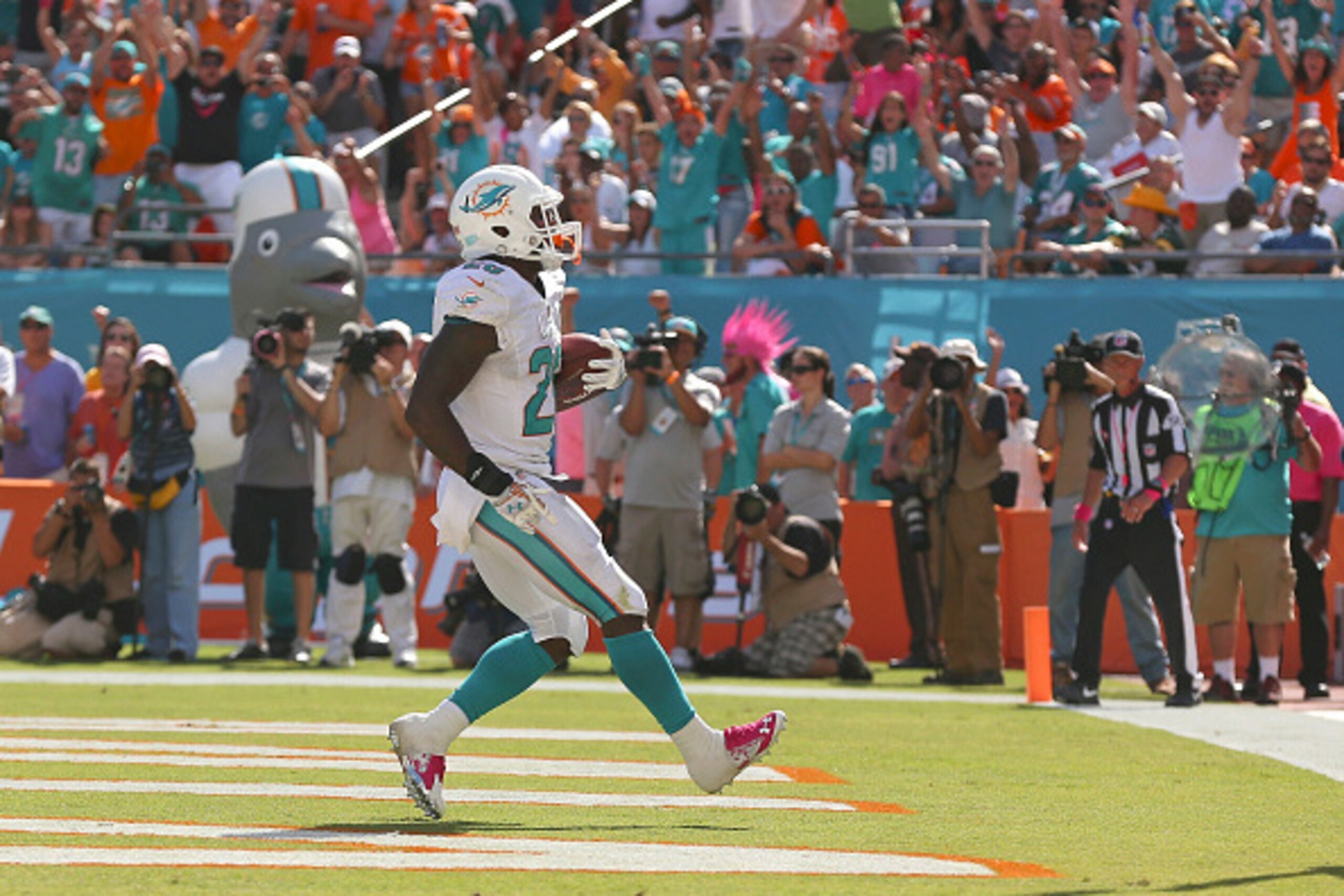 MIAMI GARDENS, FL - OCTOBER 12:  Running back Lamar Miller #26 of the Miami Dolphins runs into the endzone to score a fourth quarter touchdown during a game against the Green Bay Packers at Sun Life Stadium on October 12, 2014 in Miami Gardens, Florida.  