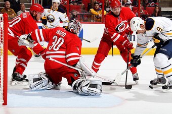 RALEIGH, NC - OCTOBER 14: Cam Ward #30 of the Carolina Hurricanes and teammates Ryan Murphy #7 and Riley Nash #20 defend the net against Cody McCormick #8 of the Buffalo Sabres during their NHL game at PNC Arena on October 14, 2014 in Raleigh, North Carol
