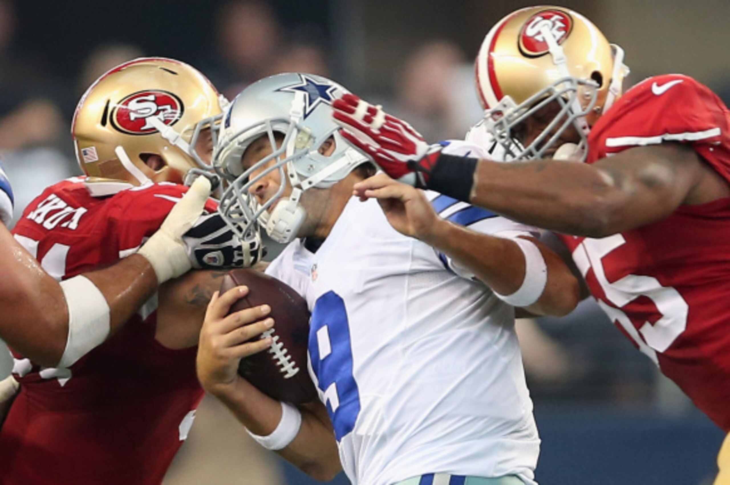 ARLINGTON, TX - SEPTEMBER 07:  Tony Romo #9 of the Dallas Cowboys is hit by Dan Skuta #51 of the San Francisco 49ers and Ahmad Brooks #55 of the San Francisco 49ers in the second half at AT&T Stadium on September 7, 2014 in Arlington, Texas.  (Photo by Ch