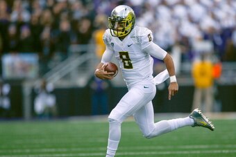SEATTLE, WA - OCTOBER 12:  Quarterback Marcus Mariota #8 of the Oregon Ducks rushes against the Washington Huskies on October 12, 2013 at Husky Stadium in Seattle, Washington.  (Photo by Otto Greule Jr/Getty Images)
