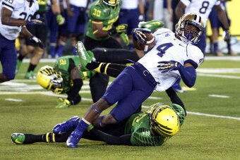 EUGENE, OR - OCTOBER 6: Wide receiver Jaydon Mickens #4 of the Washington Huskies is dragged down by defensive back Troy Hill #13 of the Oregon Ducks during the third quarter of the game on October 6, 2012 at Autzen Stadium in Eugene, Oregon. Oregon won t
