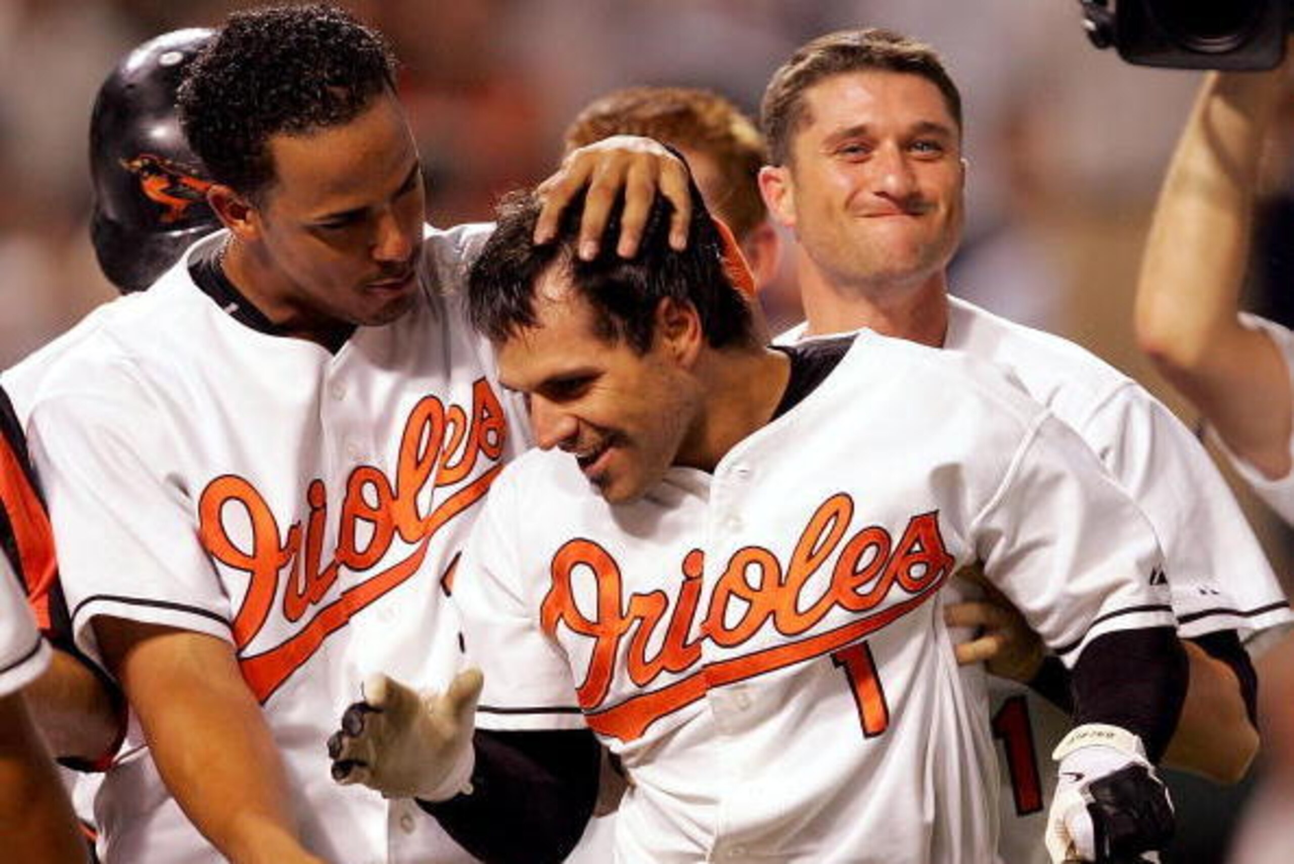BALTIMORE - JUNE 28:  Brian Roberts #1 of the Baltimore Orioles is congratulated by teammates after hitting a solo home run in the bottom of the 10th inning to win the game against the New York Yankees on June 28, 2005 at Oriole Park at Camden Yards in Ba