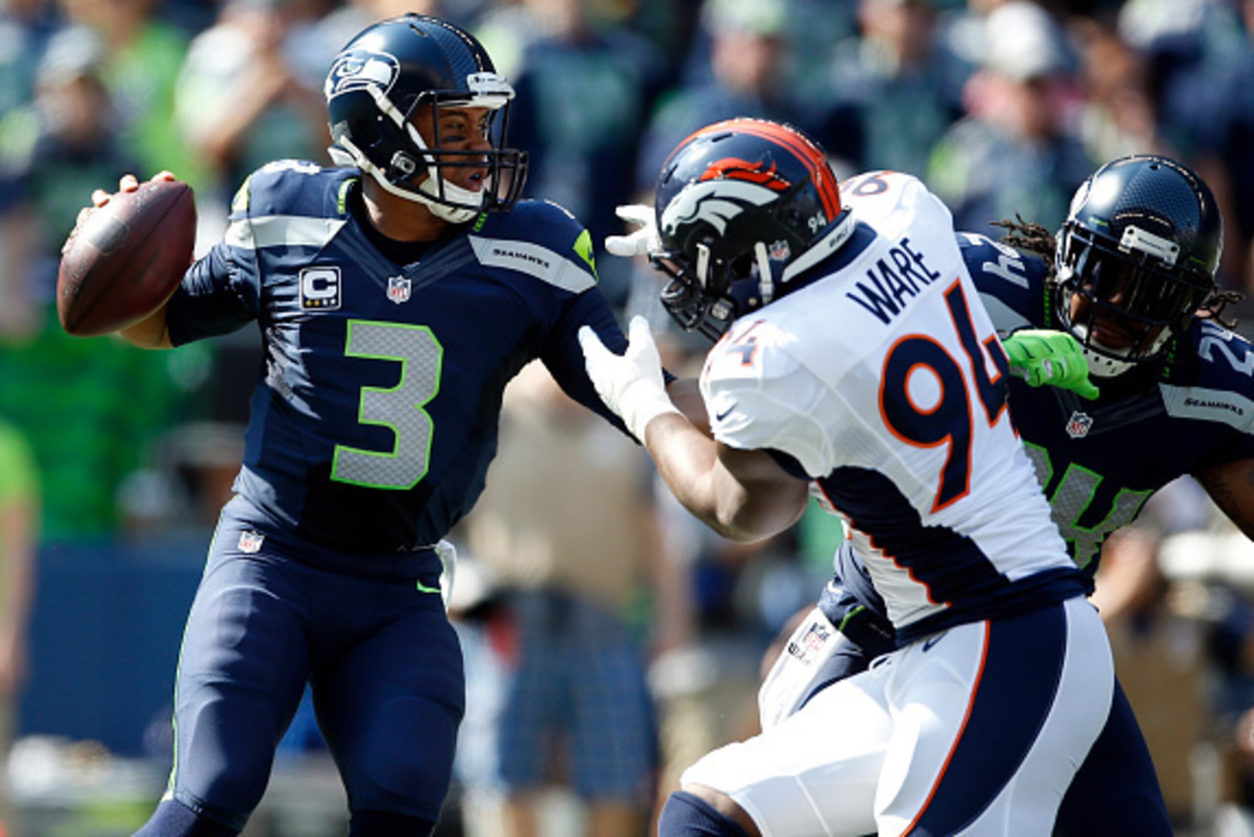 SEATTLE, WA - SEPTEMBER 21: Quarterback Russell Wilson #3 of the Seattle Seahawks is pressured by defensive end DeMarcus Ware #94 of the Denver Broncos during the first quarter of the game at CenturyLink Field on September 21, 2014 in Seattle, Washington.