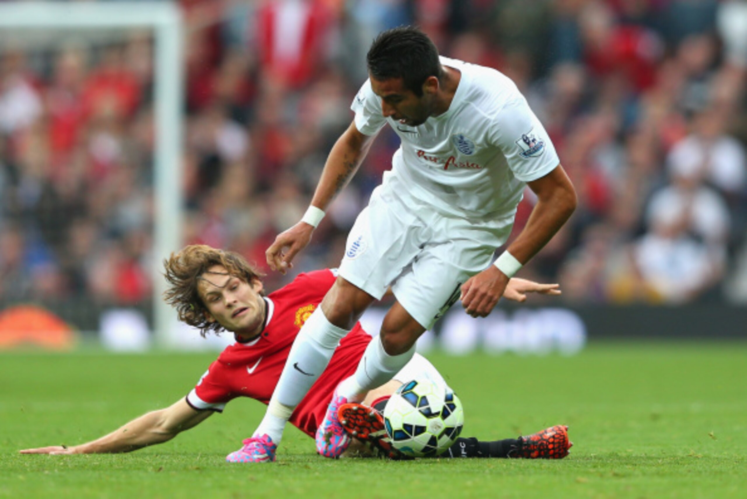 MANCHESTER, ENGLAND - SEPTEMBER 14:  Mauricio Isla of QPR is challenged by Daley Blind of Manchester United during the Barclays Premier League match between Manchester United and Queens Park Rangers at Old Trafford on September 14, 2014 in Manchester, Eng
