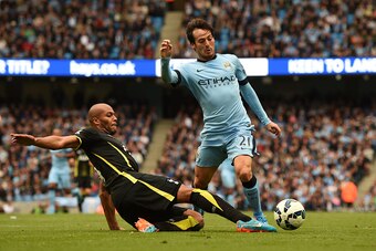 MANCHESTER, ENGLAND - OCTOBER 18:  David Silva of Manchester City wins his team's second penalty as he is brought down by Younes Kaboul of Spurs  during the Barclays Premier League match between Manchester City and Tottenham Hotspur at Etihad Stadium on O