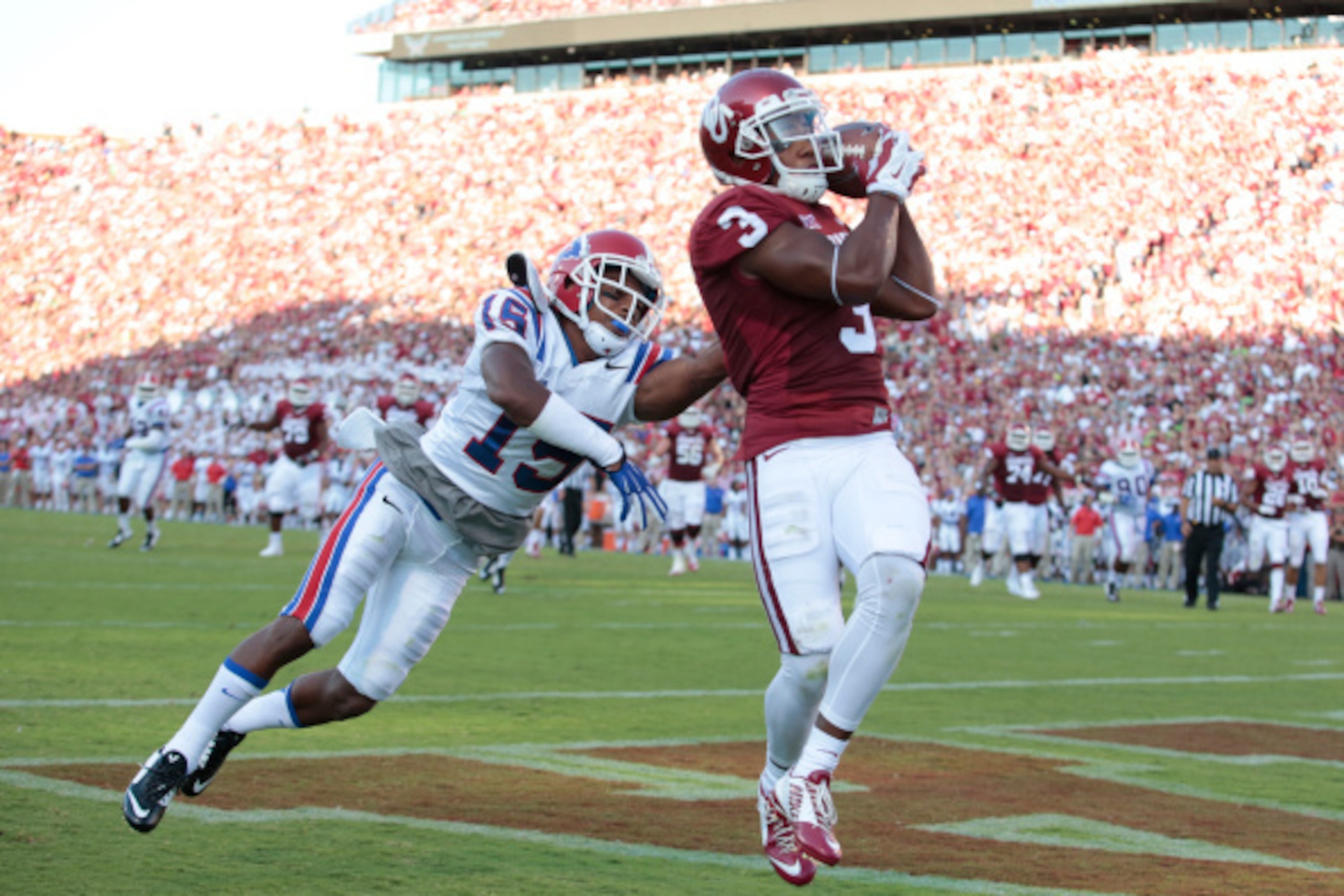 NORMAN, OK - AUGUST 30: Wide receiver Sterling Shepard #3 of the Oklahoma Sooners catches a touchdown pass as cornerback Bryson Abraham #15 of the Louisiana Tech Bulldogs defends on August 30, 2014 at Gaylord Family-Oklahoma Memorial Stadium in Norman, Ok