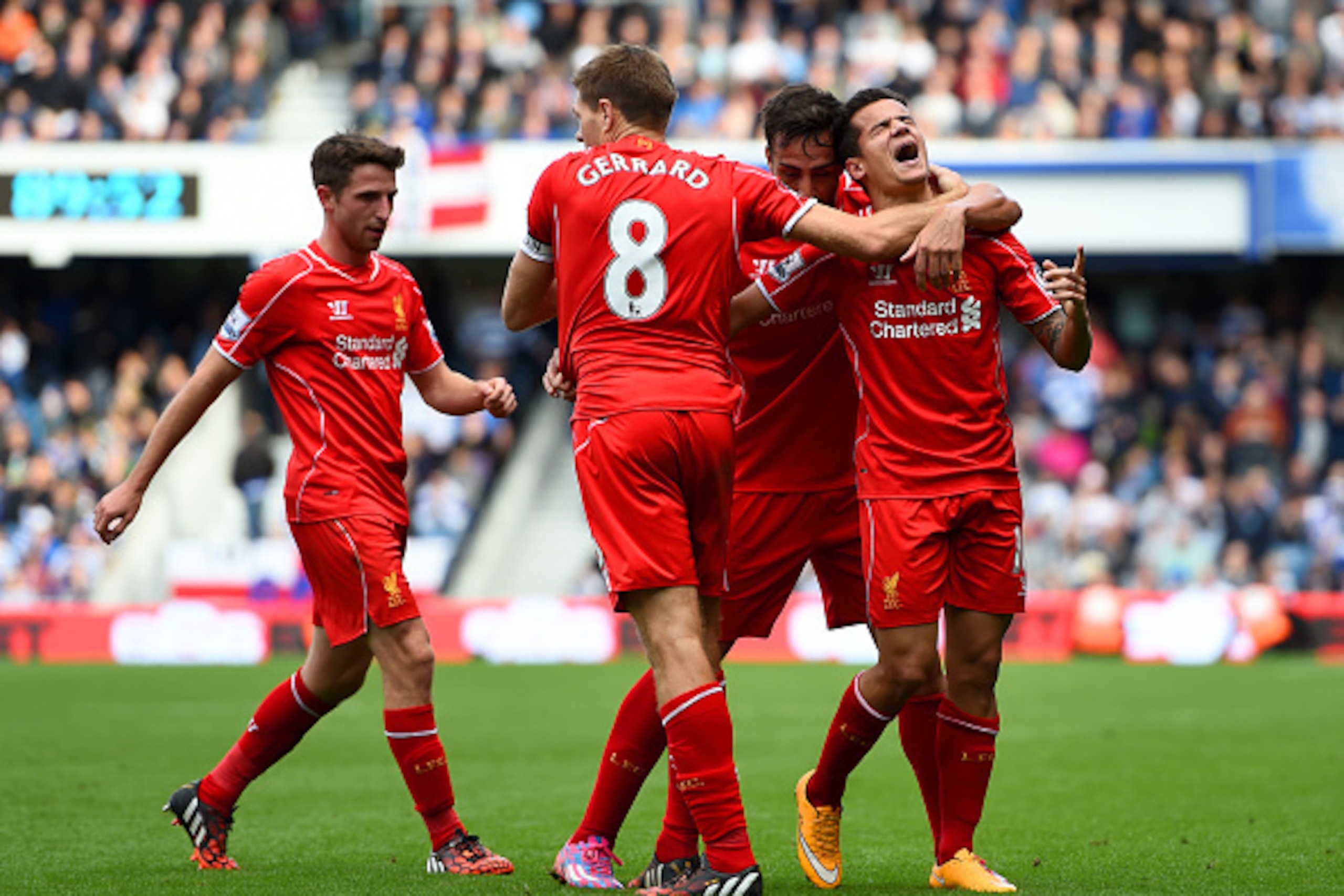 LONDON, ENGLAND - OCTOBER 19:  Philippe Coutinho of Liverpool celebrates with team-mates after scoring his team's second goal during the Barclays Premier League match between Queens Park Rangers and Liverpool at Loftus Road on October 19, 2014 in London, 