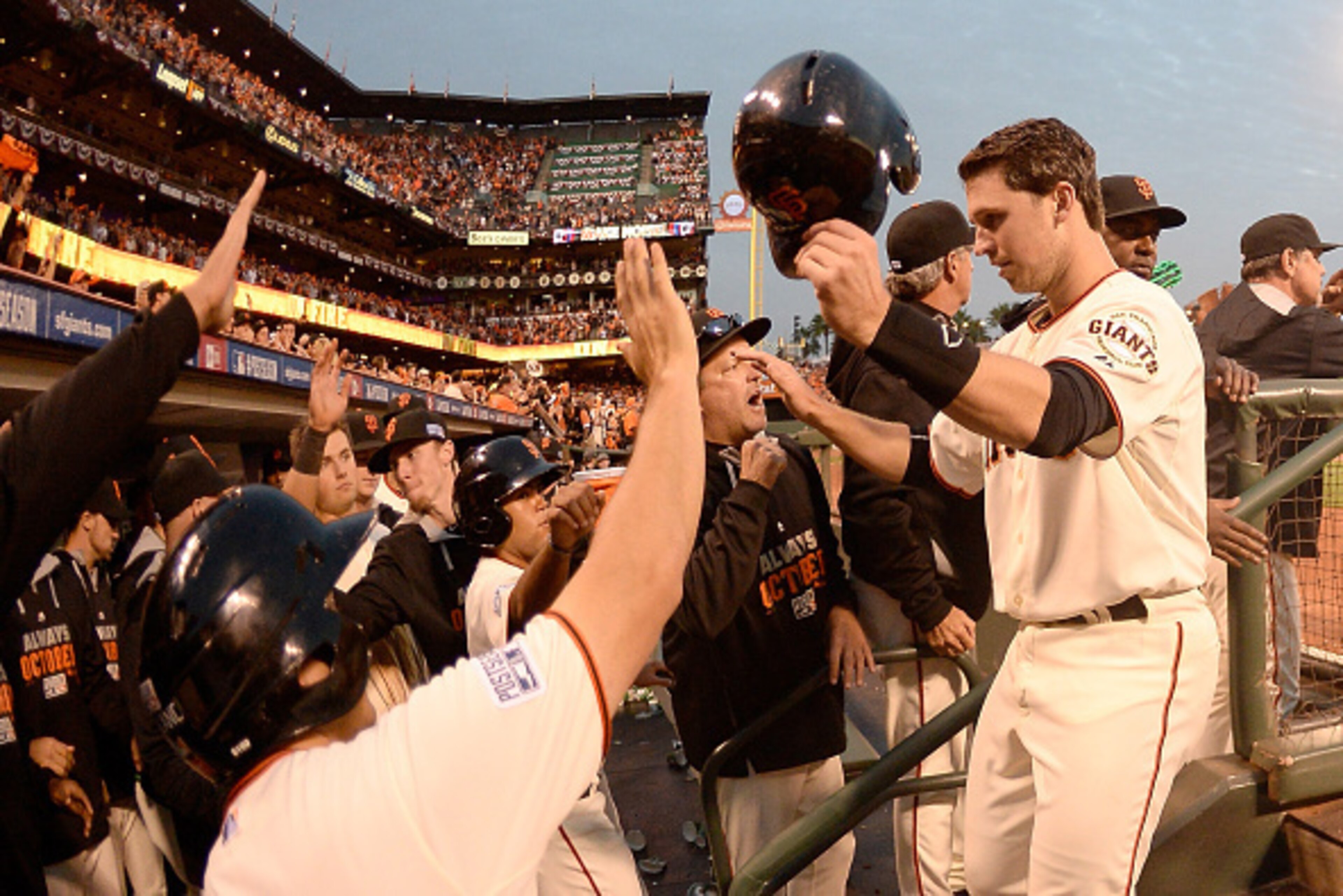 SAN FRANCISCO, CA - OCTOBER 15:  Buster Posey #28 of the San Francisco Giants celebrates with teammates after scoring in the third inning against the St. Louis Cardinals during Game Four of the National League Championship Series at AT&T Park on October 1