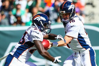 EAST RUTHERFORD, NJ - OCTOBER 12: Peyton Manning #18 of the Denver Broncos hands off to Ronnie Hillman #23 in the second quarter during a game against the New York Jets at MetLife Stadium on October 12, 2014 in East Rutherford, New Jersey.  (Photo by Elsa