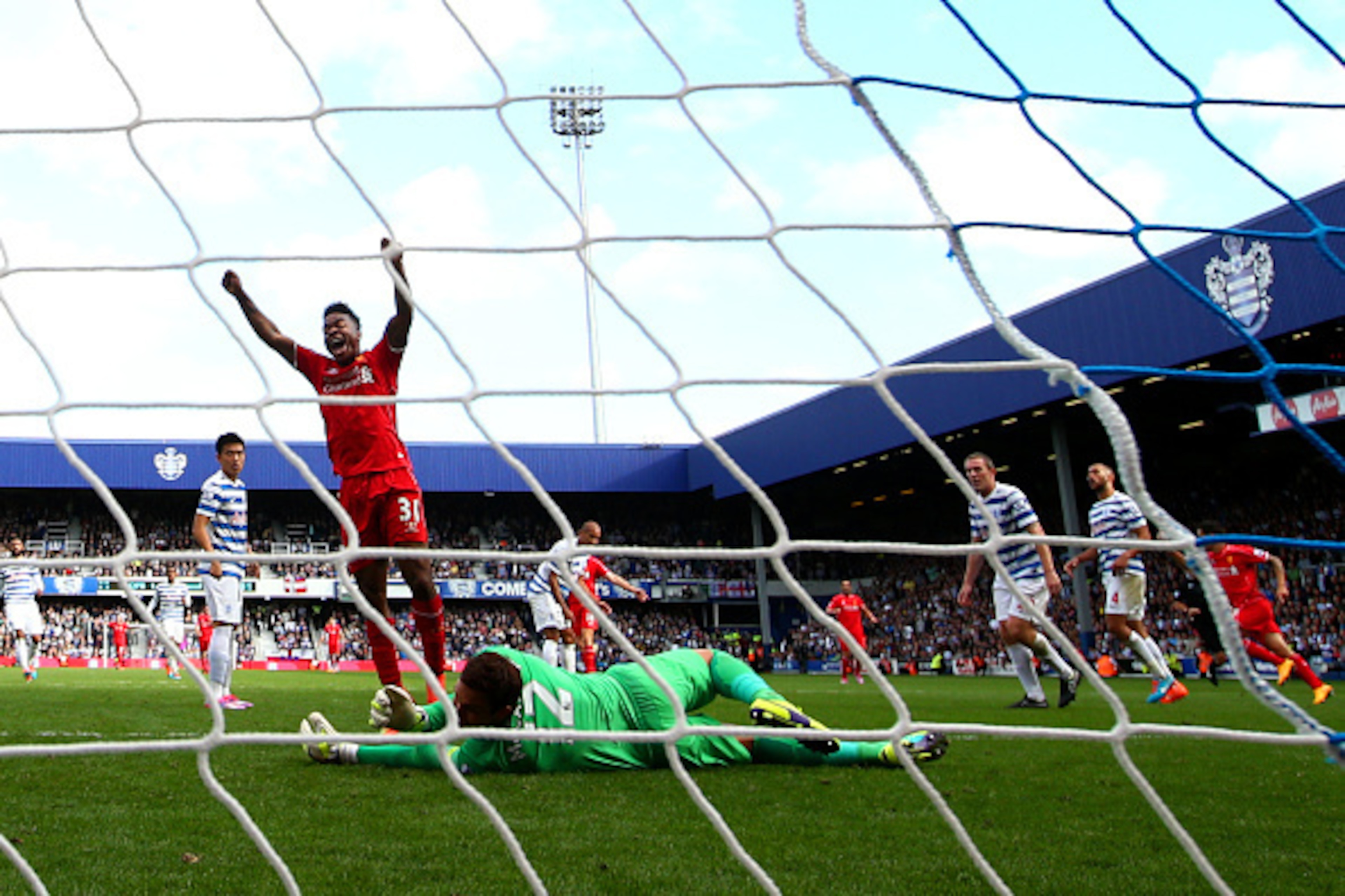 LONDON, ENGLAND - OCTOBER 19:  Raheem Sterling of Liverpool celebrates after team-mate Philippe Coutinho scored their second goal during the Barclays Premier League match between Queens Park Rangers and Liverpool at Loftus Road on October 19, 2014 in Lond