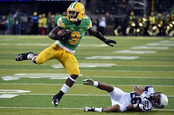 EUGENE,OR - OCTOBER 18: Running back Byron Marshall #9 of the Oregon Ducks leaps over defensive back Sidney Jones #26 of the Washington Huskies on his way to a touchdown during the second quarter of the game at Autzen Stadium on October 18, 2014 in Eugene
