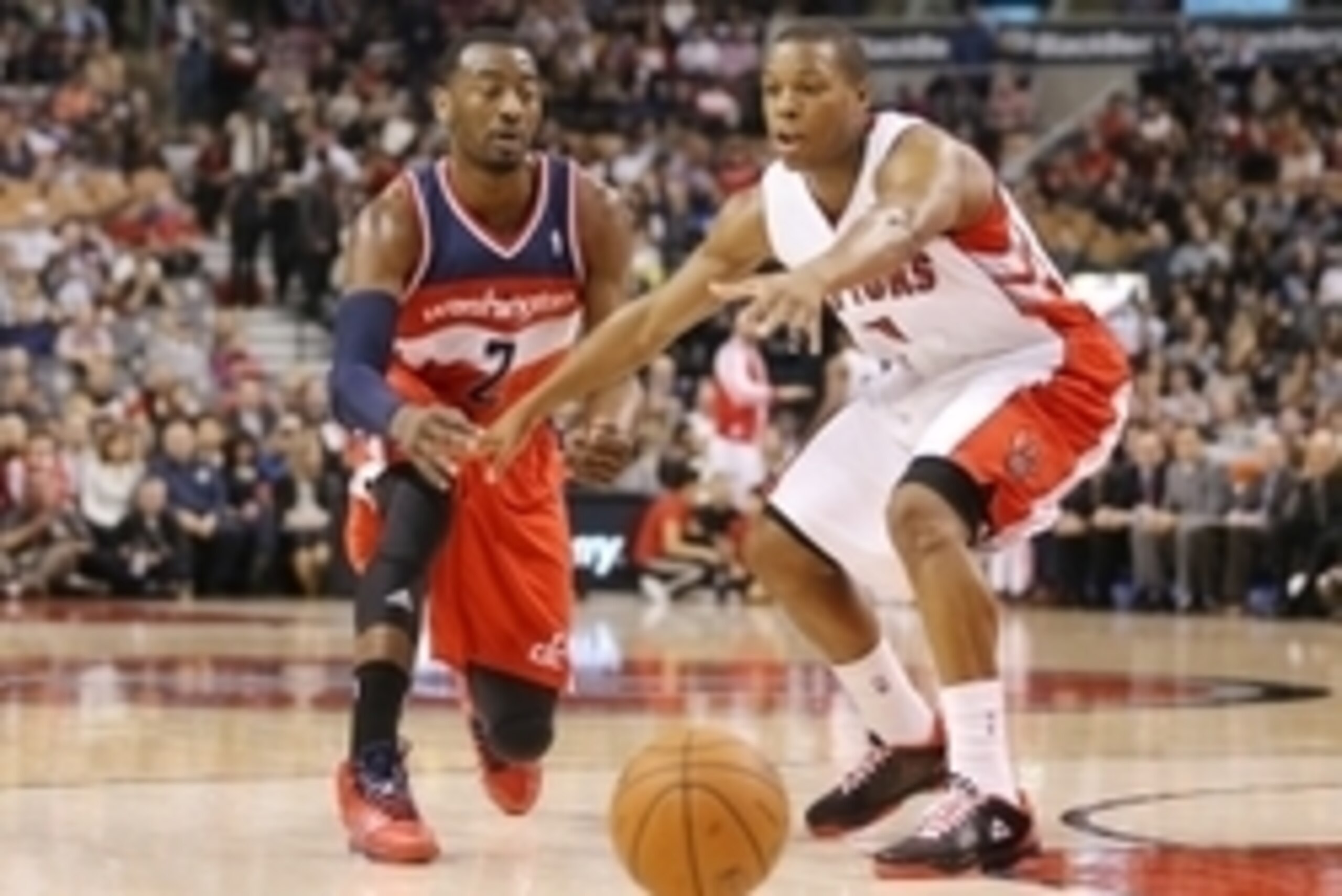 Nov 22, 2013; Toronto, Ontario, CAN; Washington Wizards guard John Wall (2) passes the ball as Toronto Raptors point guard Kyle Lowry (3) defends at Air Canada Centre. The Raptors beat the Wizards 96-88. Mandatory Credit: Tom Szczerbowski-USA TODAY Sports