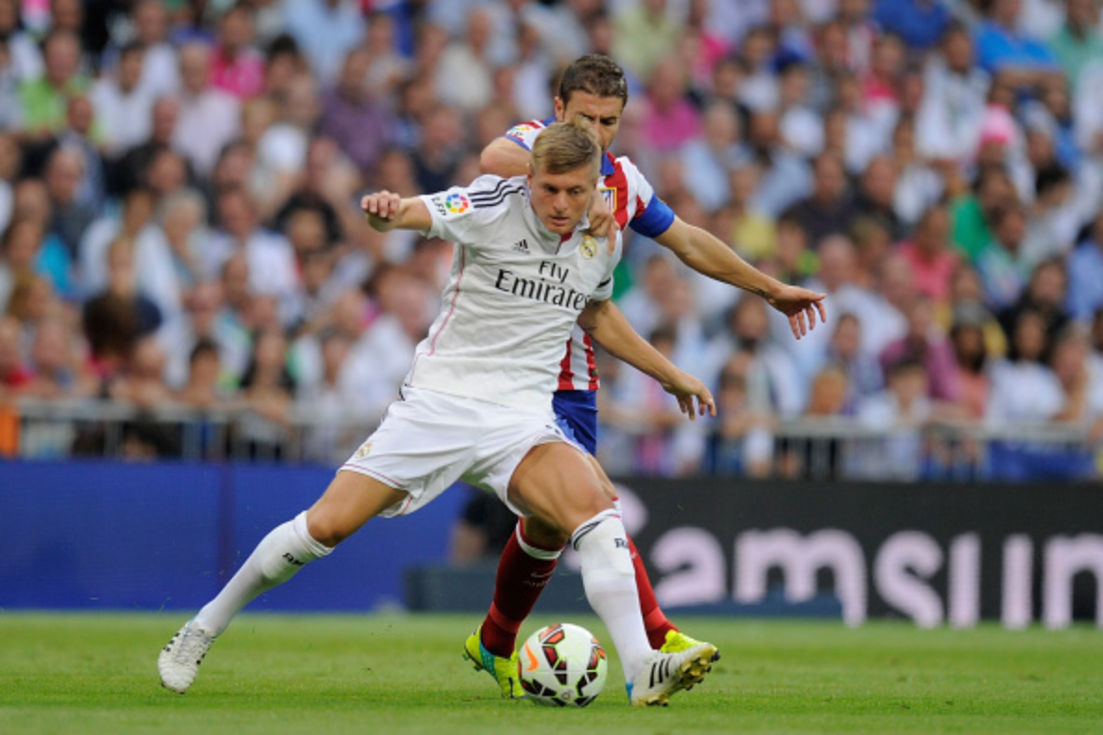 MADRID, SPAIN - SEPTEMBER 13:  Toni Kroos of Real Madrid battles for the ball against Gabi Fernandez of A tletico de Madrid during the La Liga match between Real Madrid and Atletico de Madrid at Estadio Santiago Bernabeu on September 13, 2014 in Madrid, S