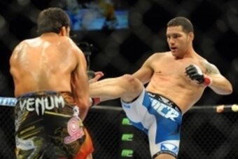 Jul 5, 2014; Las Vegas, NV, USA; Chris Weidman (red gloves ) lands a kick to Lyoto Machida (blue gloves) during a middleweight title fight at Mandalay Bay Events Center. Mandatory Credit: Stephen R. Sylvanie-USA TODAY Sports