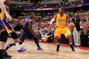 ANAHEIM, CA - OCTOBER 21: Ronnie Price #9 of the Los Angeles Lakers handles the basketball against Eric Bledsoe #2 of the Phoenix Suns on October 21, 2014 at the Honda Center in Anaheim, California. NOTE TO USER:  User expressly acknowledges and agrees th