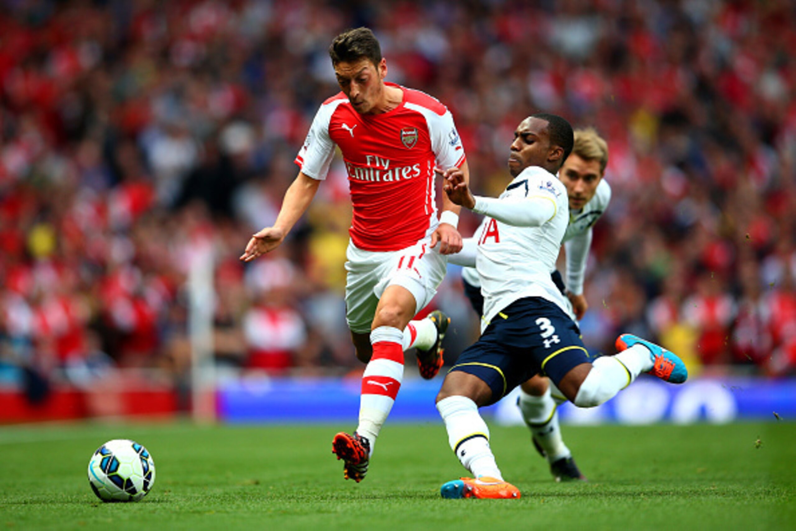 LONDON, ENGLAND - SEPTEMBER 27:  Mesut Oezil of Arsenal in action against Danny Rose of Spurs during the Barclays Premier League match between Arsenal and Tottenham Hotspur at Emirates Stadium on September 27, 2014 in London, England.  (Photo by Paul Gilh