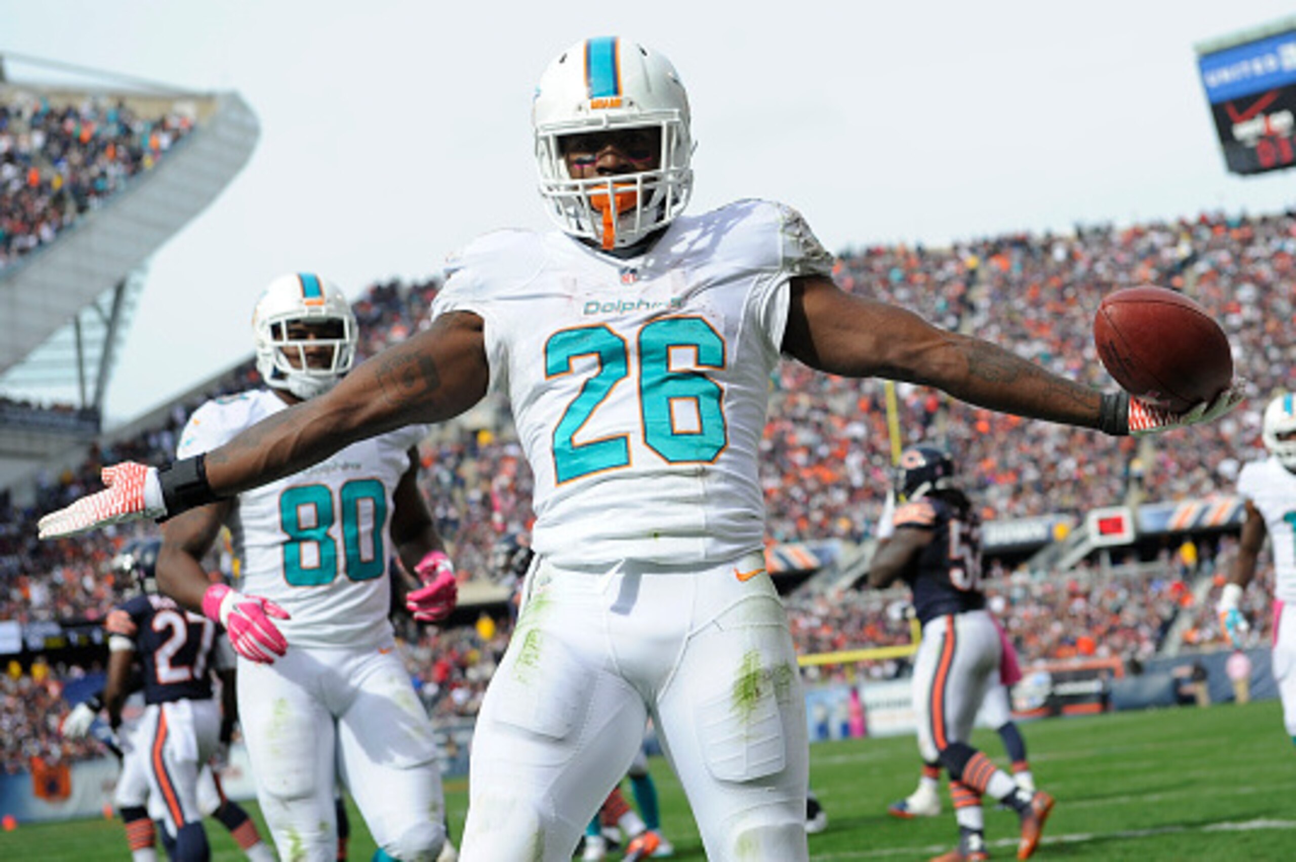 CHICAGO, IL - OCTOBER 19: Lamar Miller #26 of the Miami Dolphins celebrates his touchdown during the third quarter of the game against the Chicago Bears at Soldier Field on October 19, 2014 in Chicago. (Photo by David Banks/Getty Images)