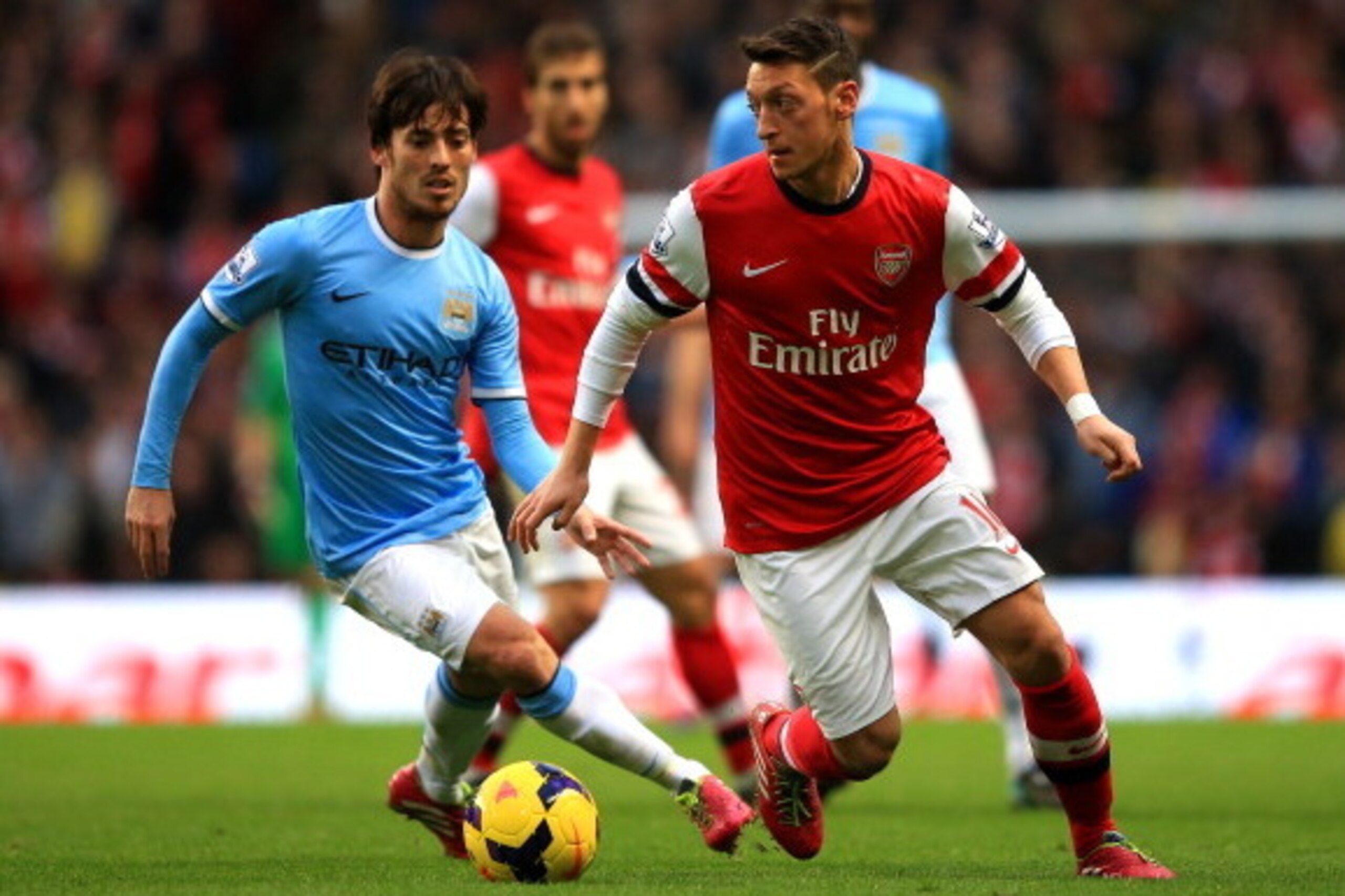 MANCHESTER, ENGLAND - DECEMBER 14: David Silva of Manchester City marshalls Mesut Oezil of Arsenal during the Barclays Premier League match between Manchester City and Arsenal at Etihad Stadium on December 14, 2013 in Manchester, England. (Photo by Richar