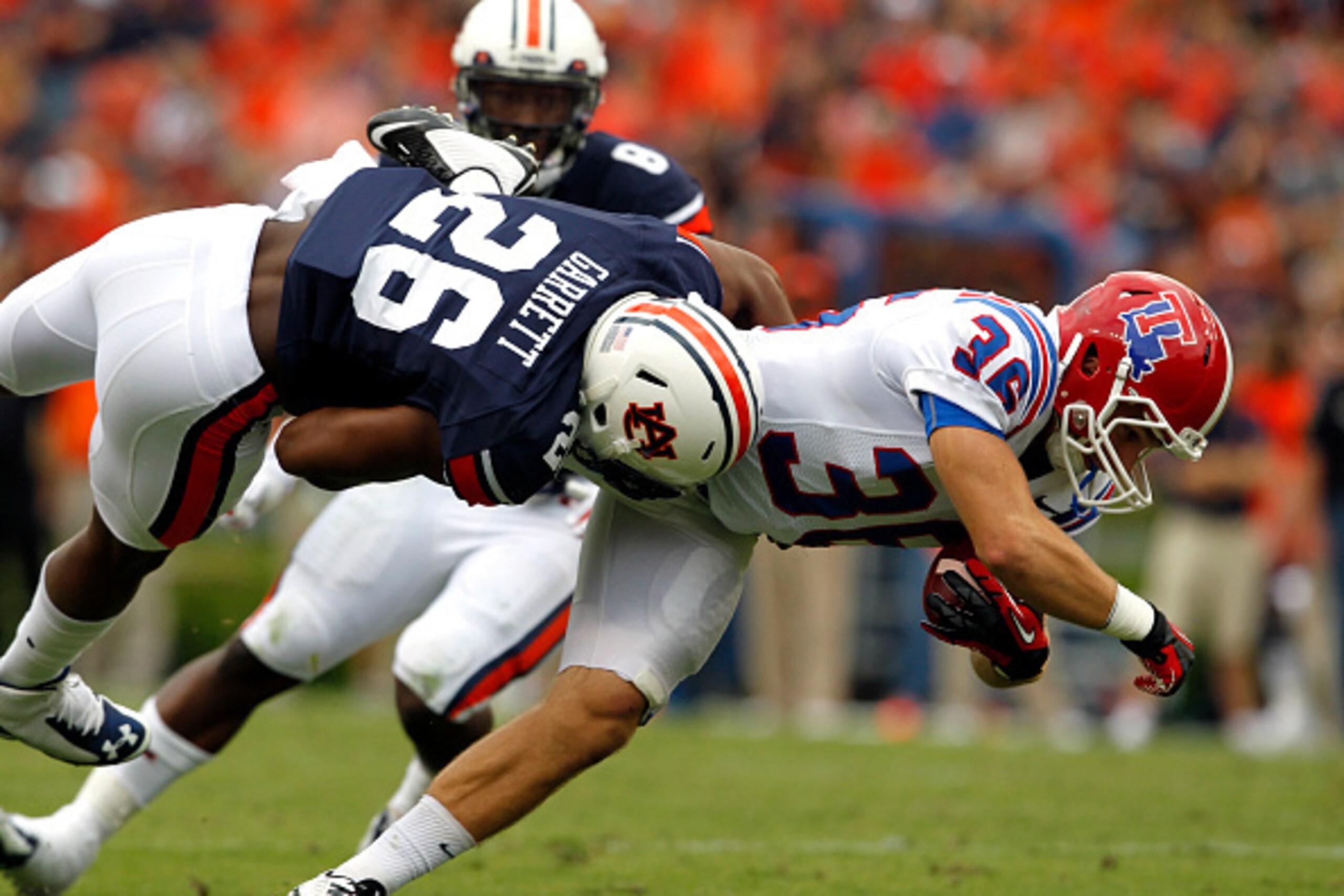 AUBURN, AL - SEPTEMBER 27:  Running back Hunter Lee #36 of the Louisiana Tech Bulldogs is hit by linebacker Justin Garrett #26 of the Auburn Tigers as he catches the ball at Jordan Hare Stadium on September 27, 2014 in Auburn, Alabama. (Photo by Butch Dil