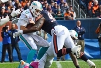 Oct 19, 2014; Chicago, IL, USA; Chicago Bears defensive tackle Jeremiah Ratliff (90) sacks Miami Dolphins quarterback Ryan Tannehill (17) during the first quarter at Soldier Field. Mandatory Credit: Mike DiNovo-USA TODAY Sports