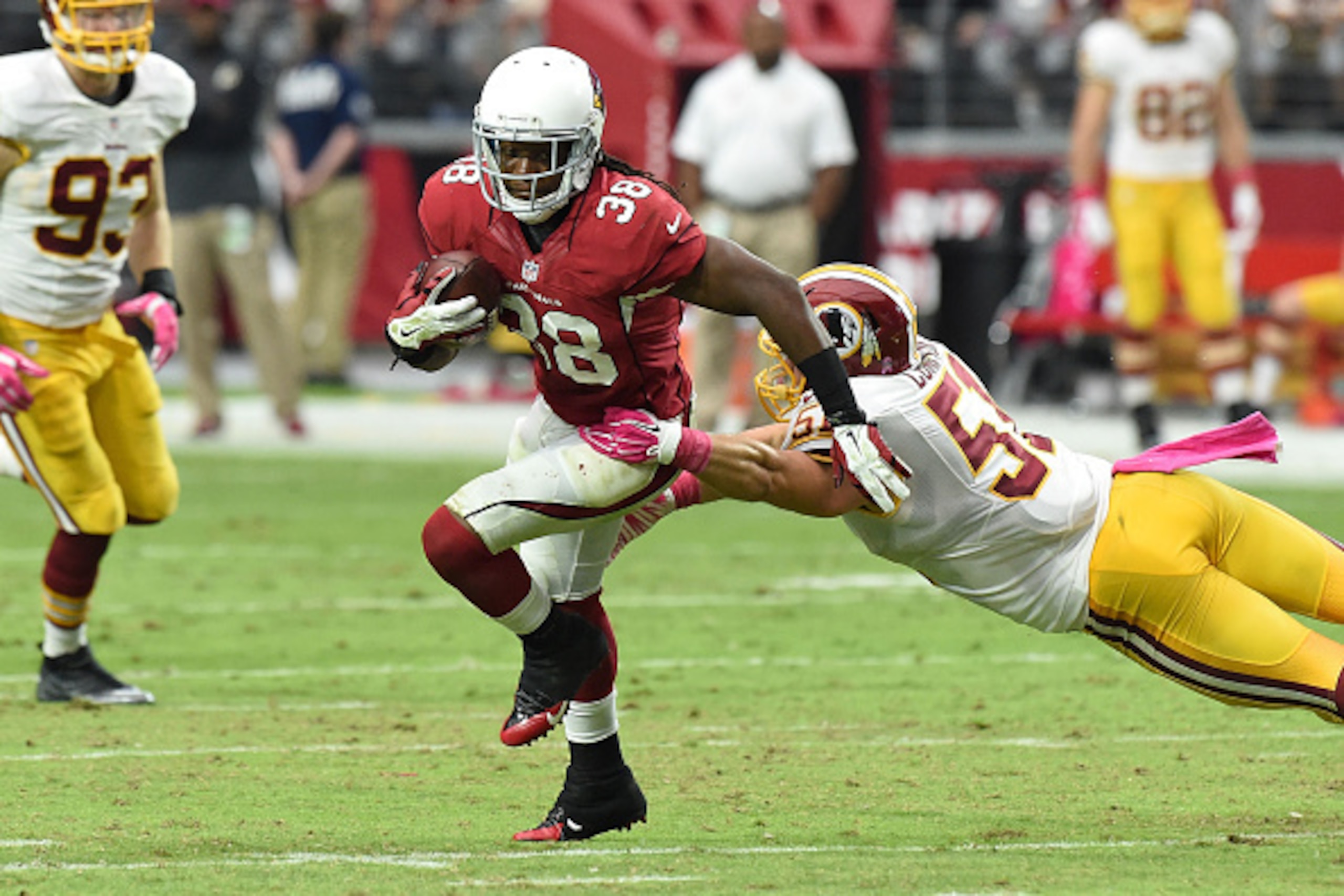 GLENDALE, AZ - OCTOBER 12: Running back Andre Ellington #38 of the Arizona Cardinals slips by linebacker Will Compton #51 of the Washington Redskins during the second half of the NFL game at University of Phoenix Stadium on October 12, 2014 in Glendale, A